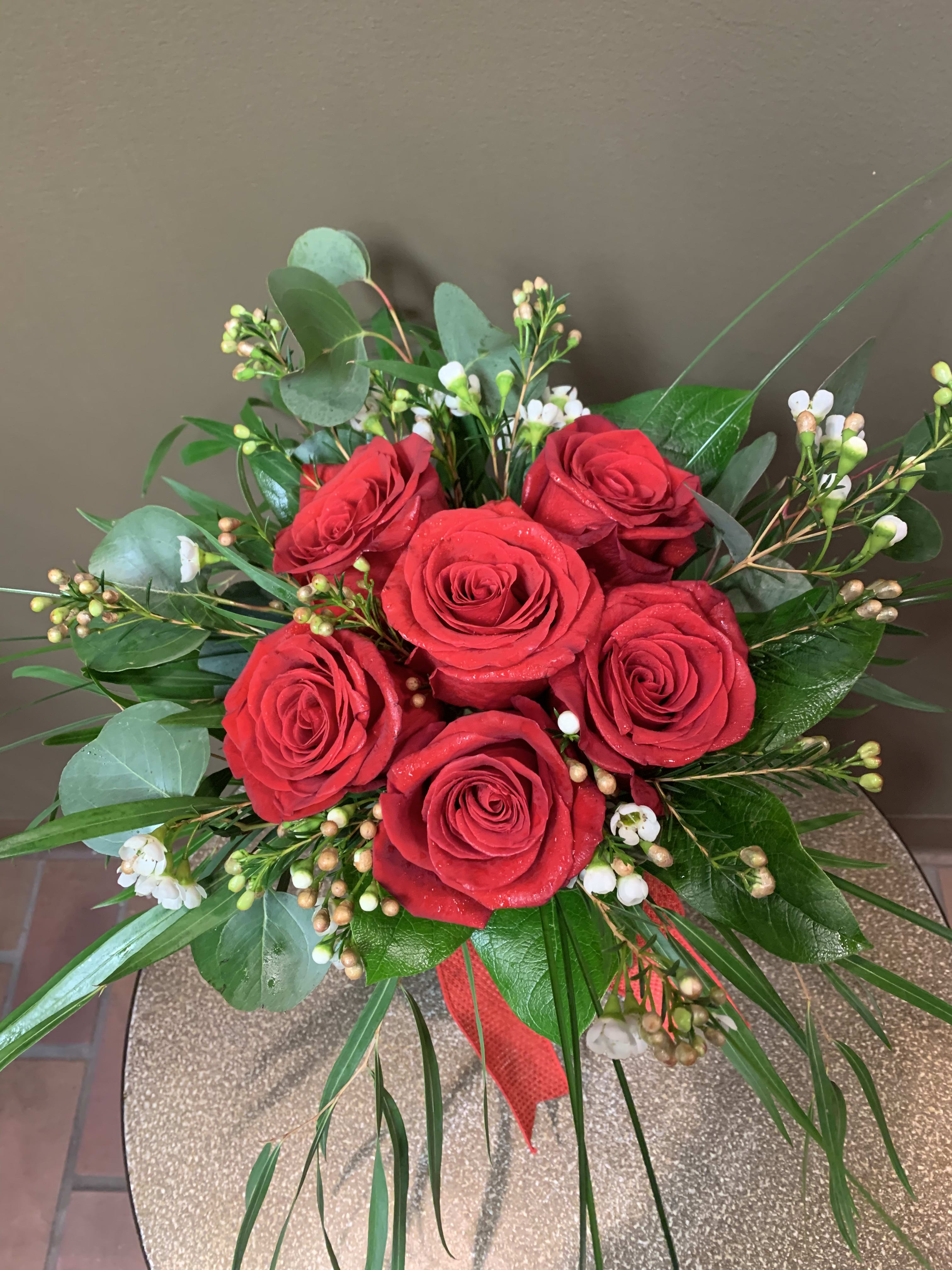 6 Low and Lush Roses  - We design most of our roses hand tied which means they are grouped shorter in the vase, surrounded by the greenery and accent flowers. This increases the vase life of the flowers substantially, and may be ordered in a variety of colors. 