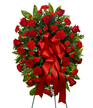 Standing Spray - Red - This sympathy standing easel is hand arranged by a local florist with stunning red flowers. Standing sprays are a wonderful way to let someone know you are thinking of them during this difficult time. Created with red roses, carnations and a decorative ribbon. Measures 21&quot;H by 32&quot;L. 