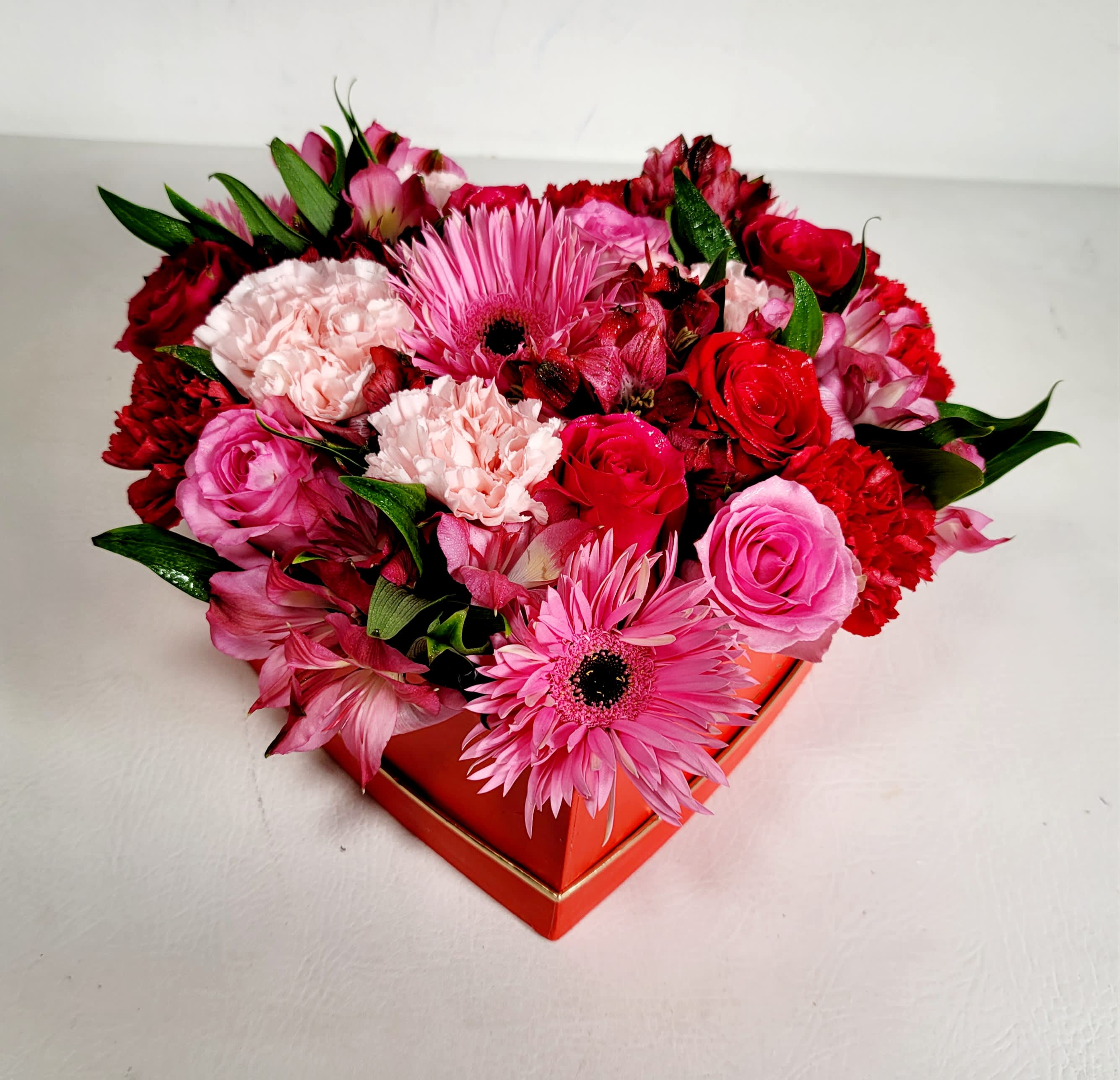 Romantic Daydream - This fun and beautiful arrangement typically includes: Red roses, Pink Roses, Pink Gerbera Daisies, Pink Carnations and Alstromeria. Subject to substitution.