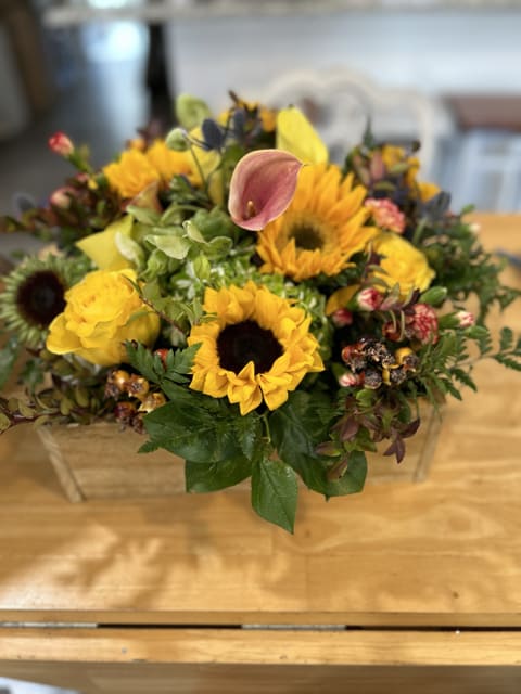 Autumn Splendor Autumn Splendor - At the heart of this arrangement are several bright sunflowers, their large, open faces and rich, brown centers immediately drawing the eye. These sunflowers are accented with deep yellow roses, adding a different texture and layer of yellow hues.