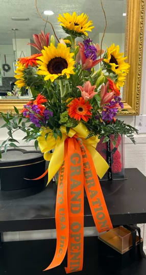 GRAND OPENING GRAND OPENING - The bouquet is a lively mix of bright sunflowers, their large sunny faces symbolizing warmth and happiness, and they are the stars of this floral display.