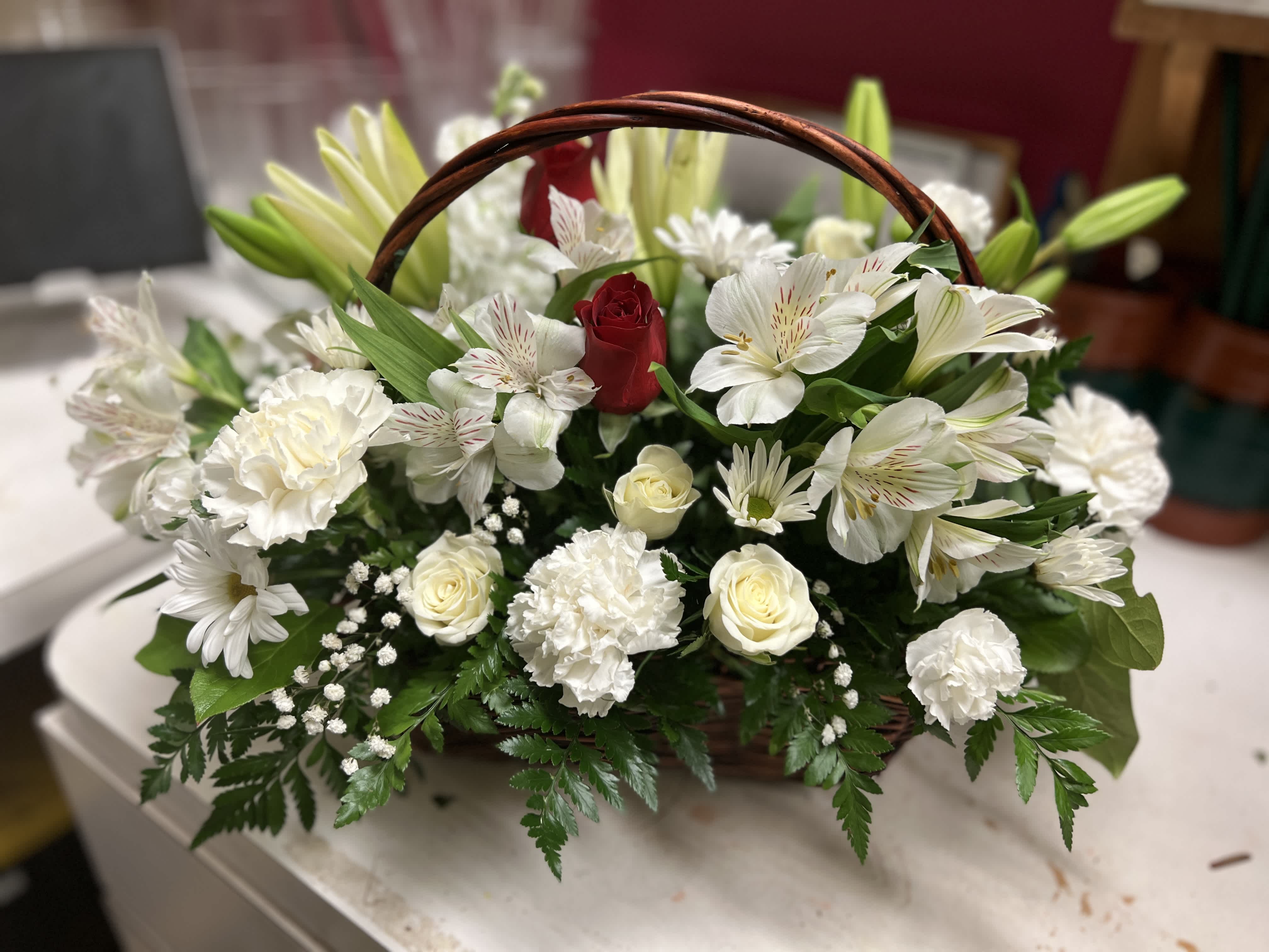 Everlasting Love - Show your everlasting love with this beautiful white basket filled with lilies, alstromeria, spray roses, stock, carnations, &amp; daisys accented with 2 red roses to represent that everlasting love of you both. **Call for additional color combinations**