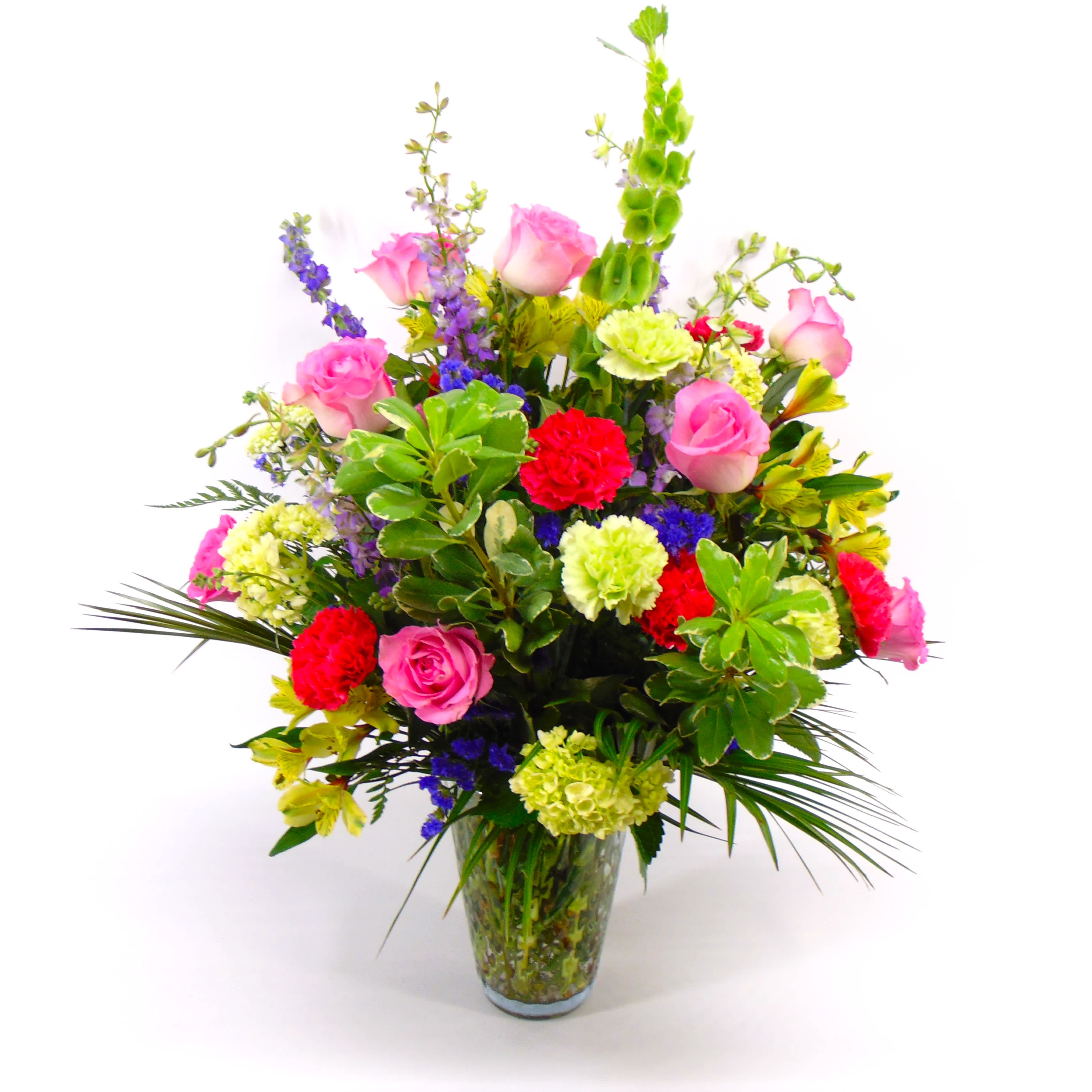 Garden Glory - A grand vase bouquet of vibrant colors and  gloroius blooms designed all-around style in a large glass vase. A garden style mix of roses, larkspur, hydrangea, larkspur, statice and carnations. 
