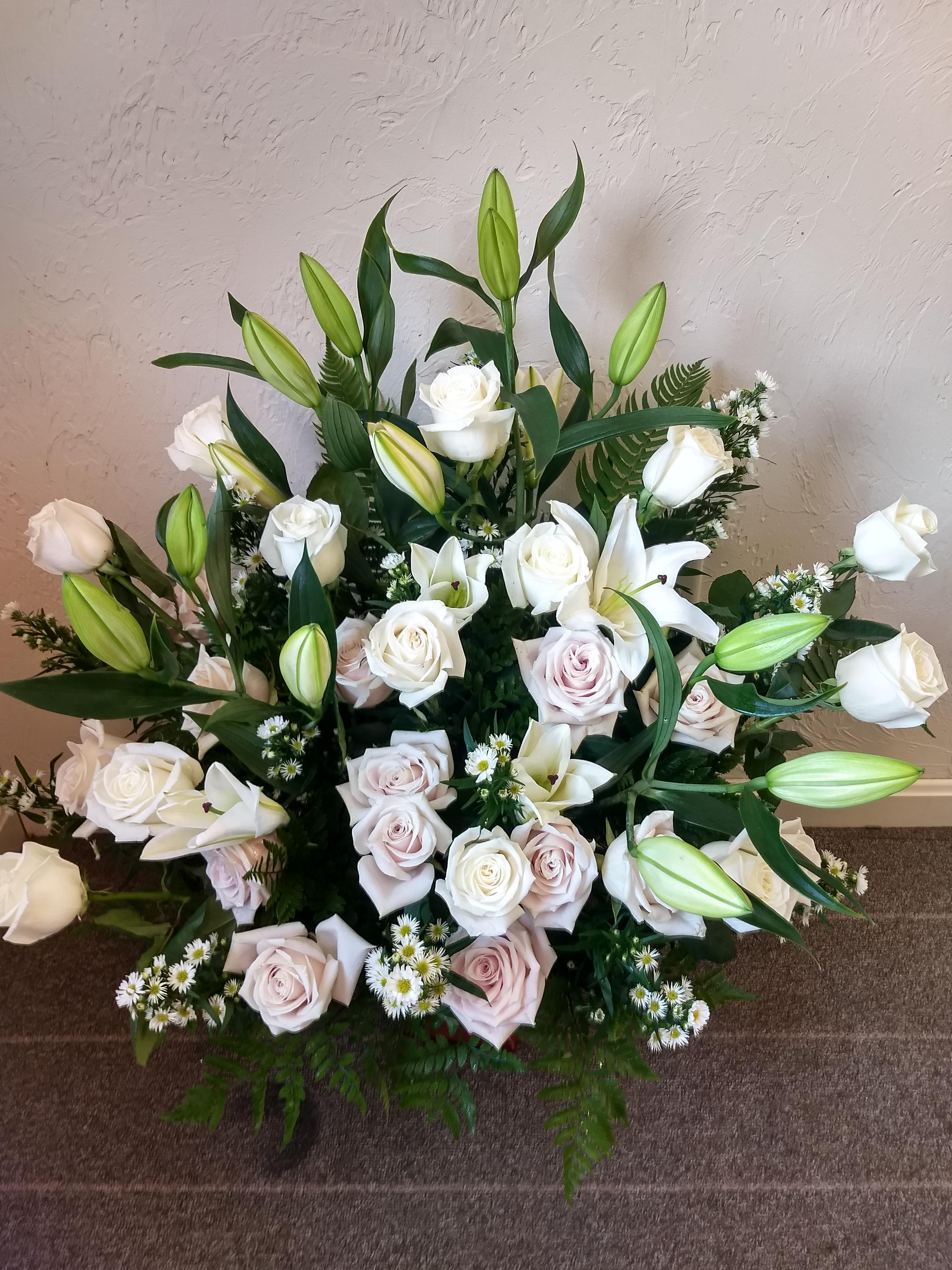  Loving Lilies and Roses Bouquet #T216-1A - A simply beautiful way to show you care. By sending this elegant arrangement to the home of those in mourning, you are letting them know they are embraced in your thoughts. And in your heart.  **** Please note: 48 hour notice MAYBE REQUIRED We custom-design this arrangement using best-of-day seasonal flowers. This image is a general representation of its size and style and may not feature the exact flowers shown. Due to disruptions in the global supply chain and staff shortages, we may have to make last minute substitutions to your selected design. If we need to make significant changes we will call you first to get your approval*** Thank you for understanding.