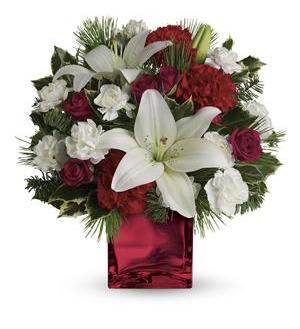Caroling in the Snow Caroling in the Snow - A gorgeous arrangement of red spray Roses, white Lilies, red Carnations, white mini Carnations arranged with mixed Christmas greens in a bright red cube. *** VASES MAY VARY WITH AVAILABILITY, WE SUB AS SIMILAR AS POSSIBLE****