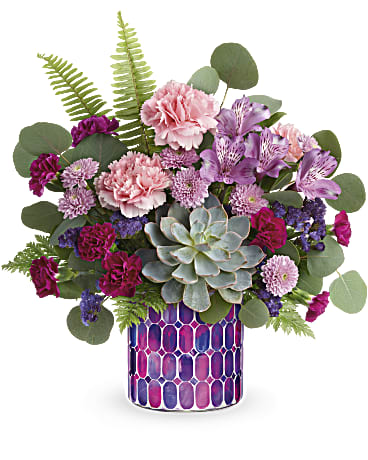 Bedazzling Beauty Bouquet Bedazzling Beauty Bouquet - Inspired by stained glass, this magnificent mosaic glass vase, filled with fabulous pink and purple blooms, is a dazzling way to celebrate someone truly special! Purple alstroemeria, pink carnations, miniature purple carnations, lavender button spray chrysanthemums and purple sinuata statice are arranged with sword fern, leatherleaf fern, and silver dollar eucalyptus. Delivered in Teleflora's Bedazzling Beauty cylinder. Orientation: All-Around