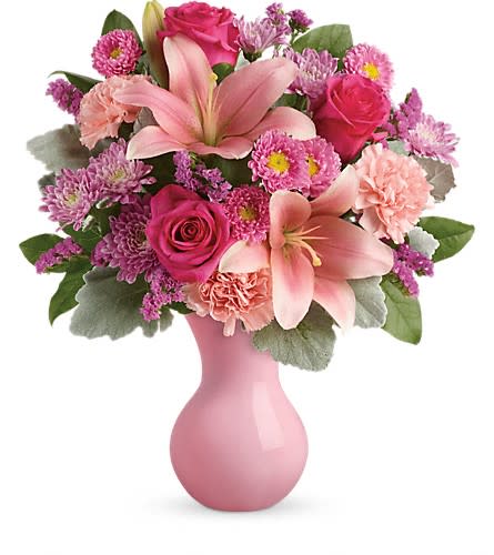 Teleflora's Lush Blush Bouquet - Inspired by the beautiful blush of happy cheeks this fabulous mix of roses lilies and carnations presented in a pink keepsake vase will make them feel like the extra special person they are! This pleasingly pink bouquet includes pink roses pink asiatic lilies pink carnations pink matsumoto asters lavender cushion spray chrysanthemums pink sinuata statice dusty miller and lemon leaf. Delivered in a pink plastic vase. Approximately 15&quot; W x 17&quot; H Orientation: One-Sided As Shown : TEV45-2A Deluxe : TEV45-2B Premium : TEV45-2C