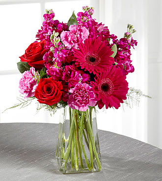 Pure Bliss Bouquet Pure Bliss Bouquet - Fuchsia Stock, hot pink Carnations, red Roses, fuchsia Gerbera Daisies and greens come together in a clear vase and are the perfect way to say "I Love You" or "Just Because"