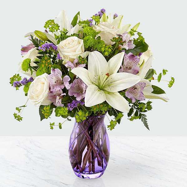 Sense of Wonder Bouquet - Cream roses with lavender Peruvian Lilies, showy white Asiatic Lilies, green button poms, lavender Statice, Bupleurum and lush greens to create an inviting springtime look.   ***** VASES MAY VARY WITH AVAILABILITY, WE SUB AS SIMILAR AS POSSIBLE*****