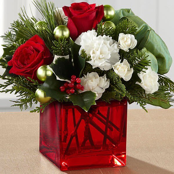Merry and Bright Merry and Bright - A mix of red roses, white mini carnations, standard carnations and green glass baubles are arranged with a mix of Christmas greens and brought together in a beautiful red cube. ***VASES MAY VARY WITH AVAILABILITY, WE SUB AS SIMILAR AS POSSIBLE***