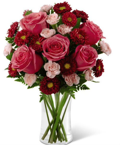 Precious Heart Bouquet Precious Heart Bouquet - A bright bouquet of Hot Pink Roses, Red Matsumoto Asters, and Pale Pink Mini Carnations with greens in a clear vase.