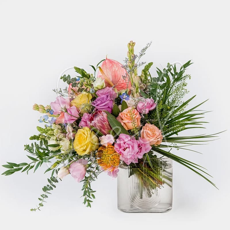 Lean On Me - Amber Glass / Art Deco vase featuring asymmetrical bouquet of lush wild florals including protea, pin cushions, lisianthus, snapdragons, wax, roses and eucalyptus.