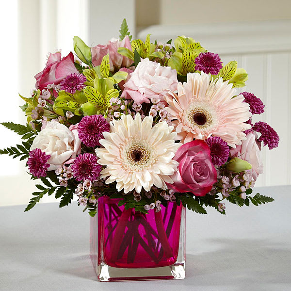 Perfect Princess New Baby Bouquet Perfect Princess New Baby Bouquet - Pale pink gerbera daisies, lavender roses, pale pink double lisianthus, green Peruvian Lilies, clusters of pink waxflower and burgundy button poms. Accented with lush greens in a pretty pink vase. **We currently don't have this vase, but we will substitute with one as similar as possible**