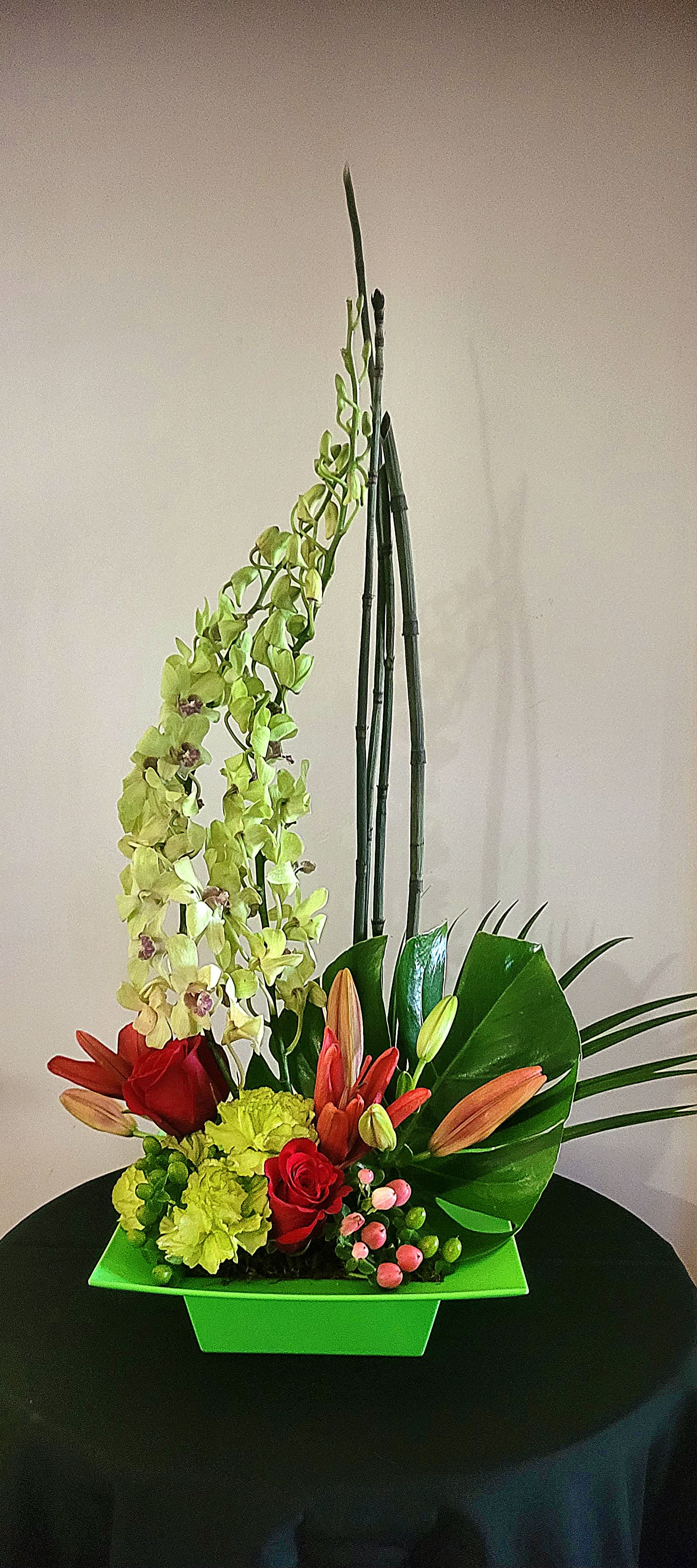 Zen Artistry II Zen Artistry II - If you want a modern and sculptural floral arrangement, this striking bouquet, with delicate purple orchids, mini bamboo, and a colorful mix of blooms, will accomplish it. Aesthetically similar to "Zen Artistry," this variance is designed with green dendrobium orchids, roses, lilies, and carnations. An ideal design for an office or a small space. Orientation: One-Sided