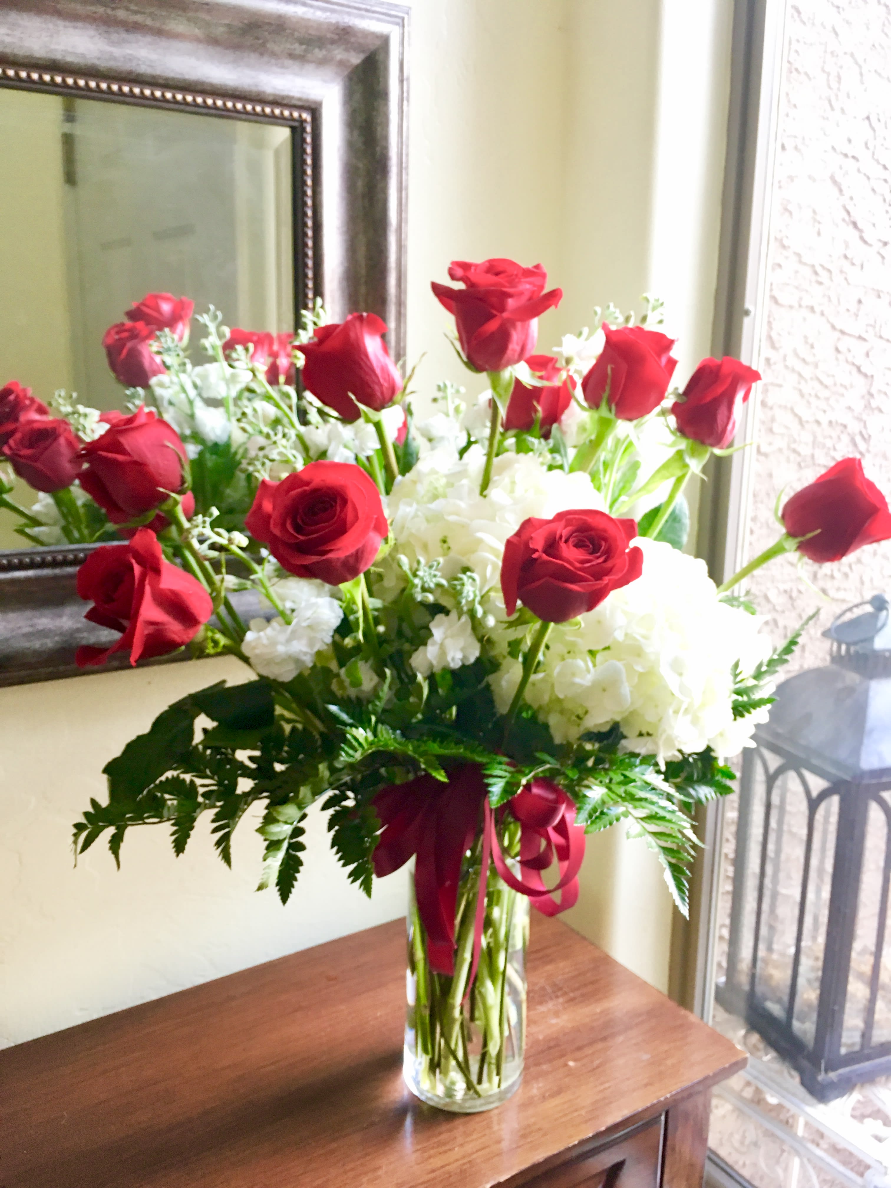 Hearts Ablaze - This beauty is a show stopper meant to impress your loved one!  The arrangement features a dozen red roses along with fluffy white hydrangea and greenery!
