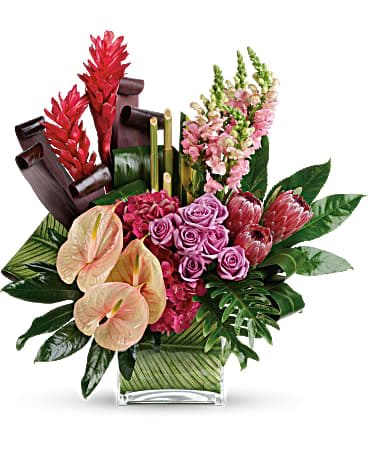 Tropical Island Bouquet - At once elegant and otherworldly, this Island-inspired art piece is a journey of color and texture. Pink hydrangea and lavender roses mix with tropical red ginger, pale pink anthuriums and a beautiful variety of leaves for a glorious gift! This tropical arrangement includes pink hydrangea, lavender roses, anthuriums, pink ice protea, pink snapdragons, large red ginger, aralia leaves and other tropical leaves. Delivered in a large square vase. Orientation: One-Sided 