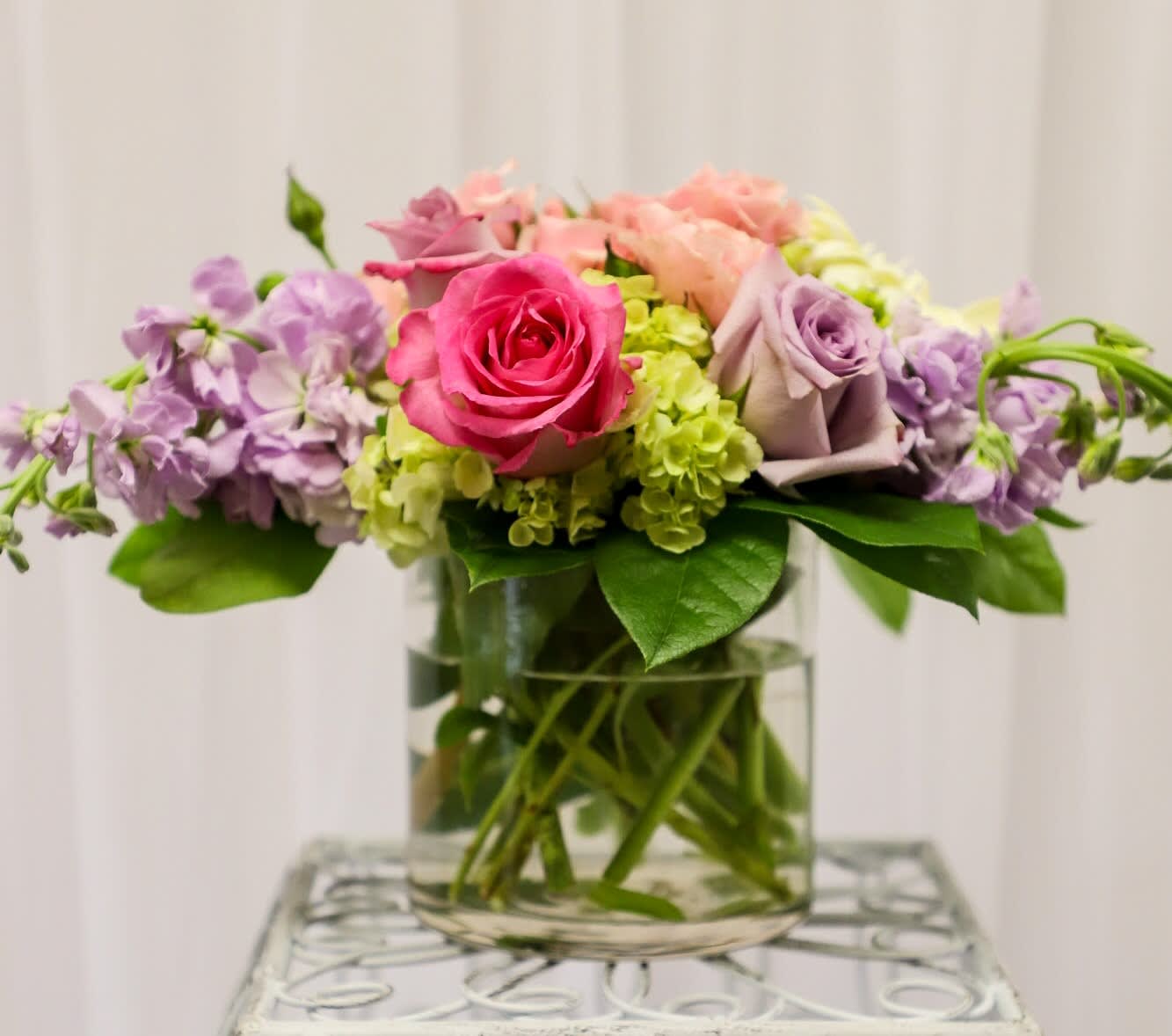 Sweet Pastels  - This low cylinder arrangements consists of all shades of pastel colors. Flowers used are hydrangea, roses, spray roses, gerbera daisy's and more! 