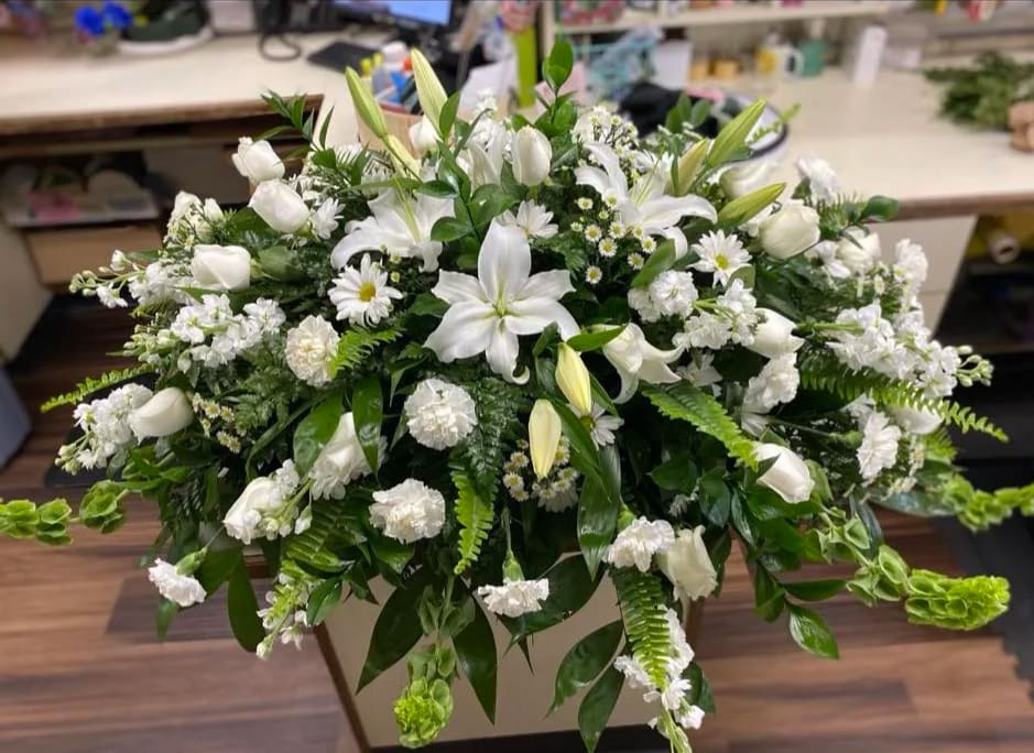 All white casket sprayBN by Llanes Flower Shop, LLC