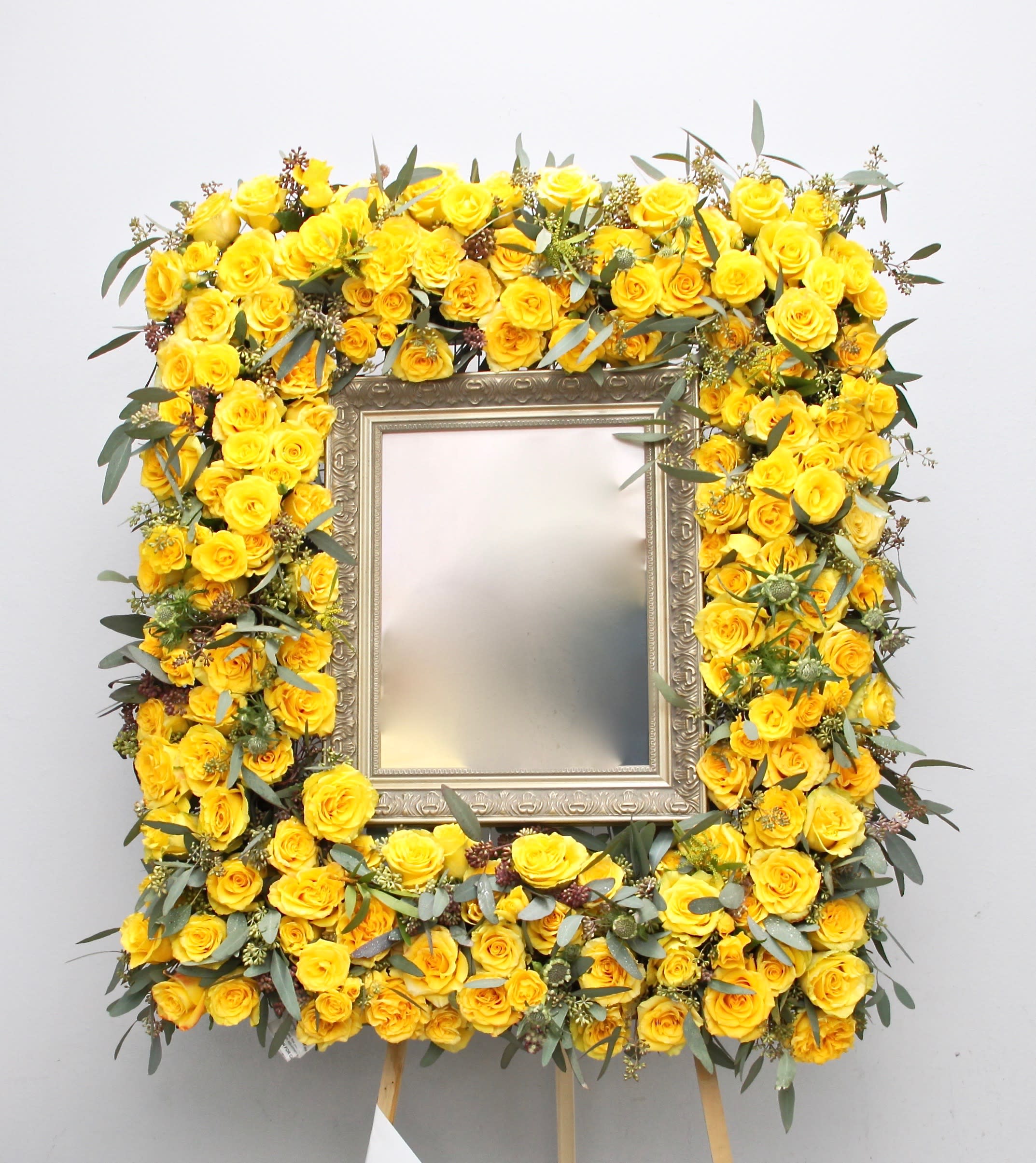 Yellow Roses Frame  - This frame is made up of bright yellow roses and seasonal greens. It stands at approximately 32 inches tall in the standard size. Frame is not included. Coordinate with use for drop off and allow 2-3 days. 11''x14'' frame is best.   