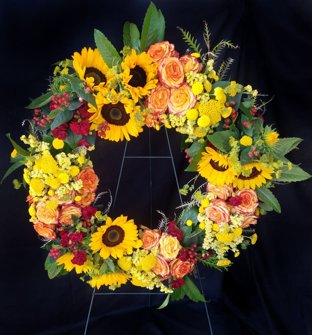 Understanding Understanding - Beautiful wreath including sunflowers and roses with accents of carnations and foliage. *Flowers subject to change based on supply*