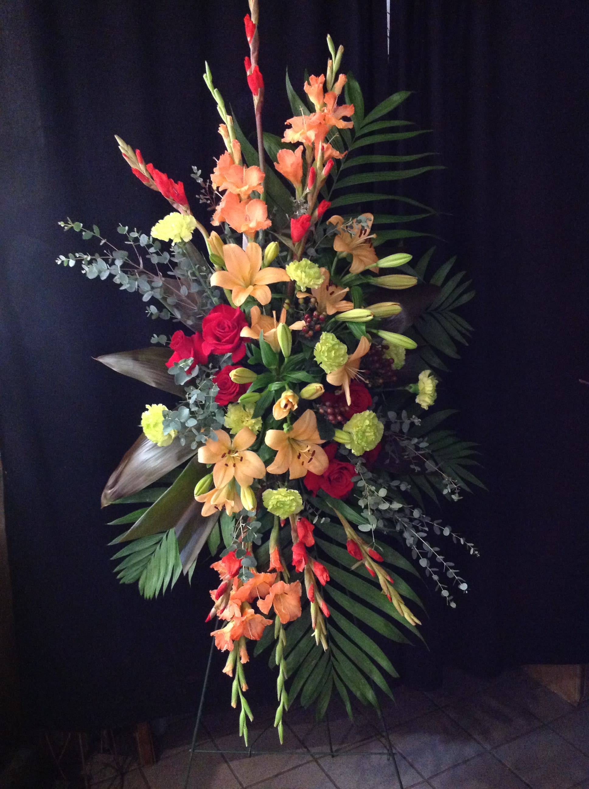 Warmth Warmth - Peach and red tropical style flowers arranged in a standing spray. *Flowers subject to change based on supply*