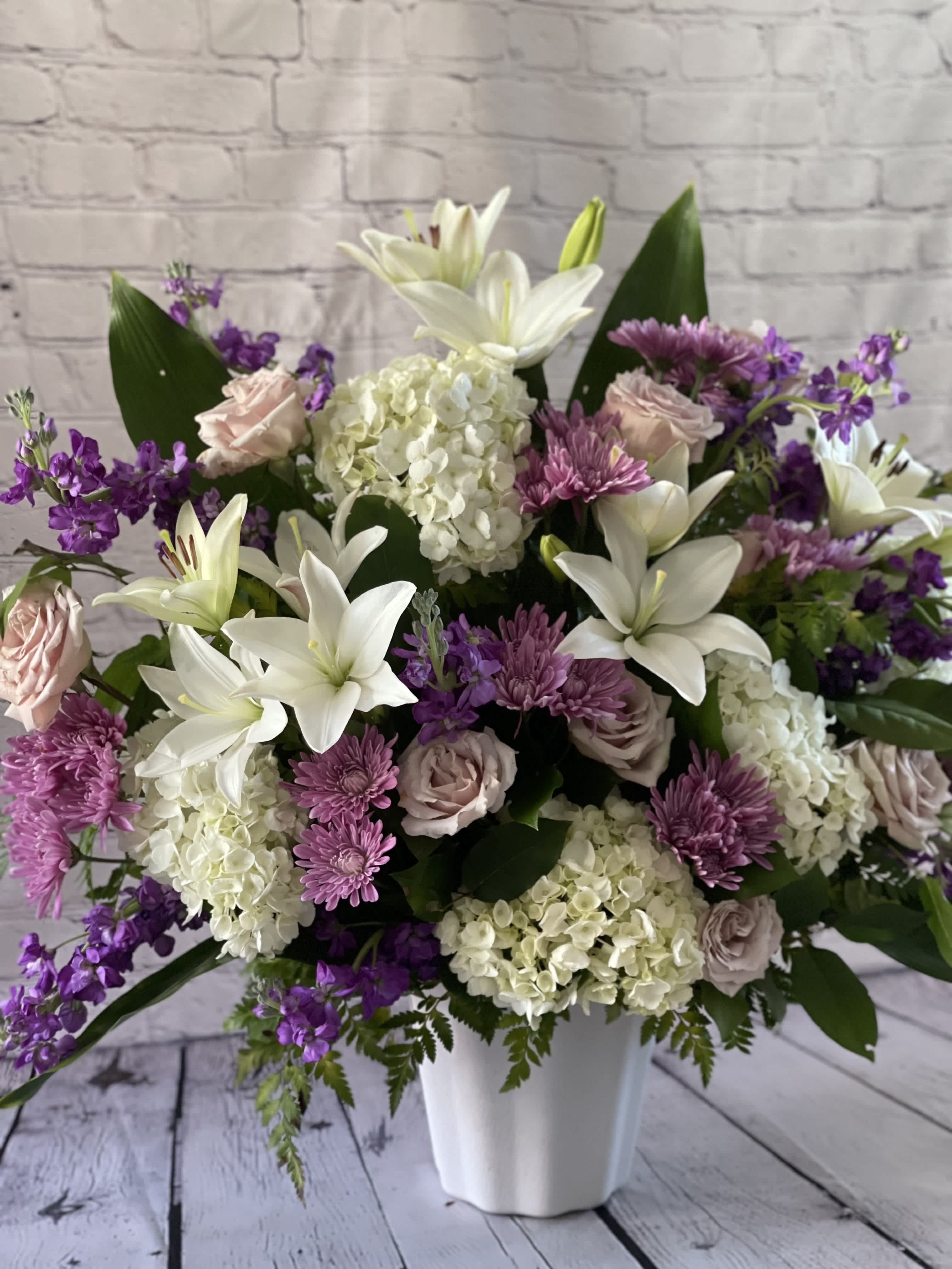 Sweet Dream Bouquet - Introducing the Sweet Dream Bouquet, a delightful floral arrangement that will transport you to a world of pure serenity. Handcrafted by our expert florists, this exquisite bouquet is designed to bring a touch of elegance and tranquility to any space.   Adorned in a classic white vase, the Sweet Dream Bouquet is a captivating sight to behold. The vase elegantly showcases a variety of vibrant blossoms, carefully selected for their beauty and fragrance. Picture a harmonious blend of delicate roses, enchanting lilies, and graceful carnations, each petal exuding a gentle allure.   Whether you're looking to brighten up your living room, add a touch of sophistication to your office, or surprise a loved one with an unforgettable gift, the Sweet Dream Bouquet is the perfect choice. Its timeless beauty and aromatic essence will fill any space with a sense of enchantment and tranquility.   As professional florists, we take pride in curating the freshest and most vibrant flowers for our customers. Each stem is carefully handpicked  