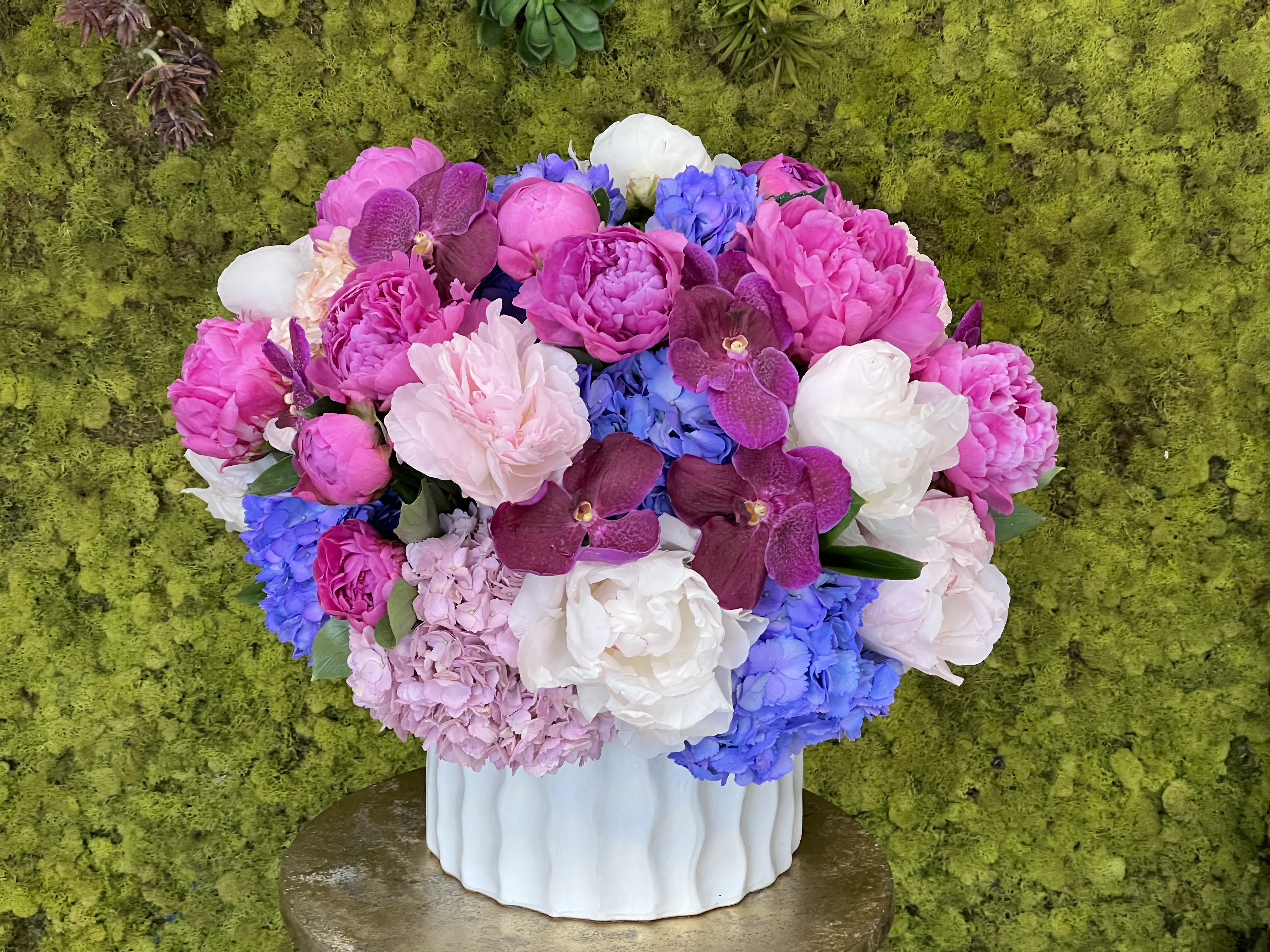 Cheerful Love - A luscious combination of pinks and purples with elegant orchids, peonies, and hydrangeas.  Decorative ceramic vase subject to availability.  vase size: 10x10&quot;