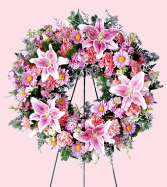 Pastel Memories Wreath Pastel Memories Wreath - Stargazer lilies are used to remind how special she was in this soft pink wreath. Appropriate to send to the funeral home. Arrangement is delivered with an easel for display. Approximately 24"H x 24"W