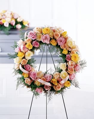 Vibrant Sympathy Wreath Vibrant Sympathy Wreath - Send this spectacular arrangement: a bounty of pink, yellow, peach and cream roses with complimentary greens and a ribbon. Appropriate to send to the funeral home. Arrangement is delivered with an easel for display. Approximately 24" dia. H" X W"
