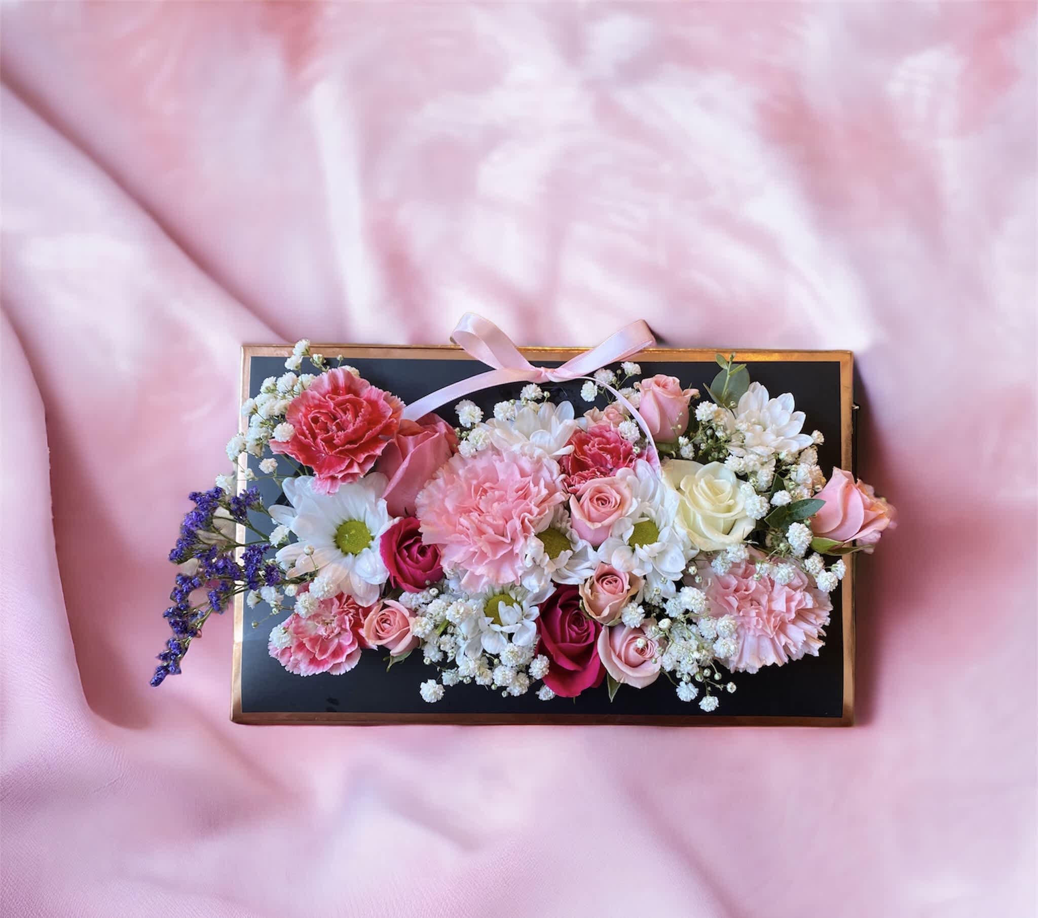  Pinky - Everyone's crushing on this precious Valentine's Day gift! Bursting with classic pink blooms, this unique and elegant arrangement is sure to make her heart flutter. Ribbon is subject to substitution based on available inventory.