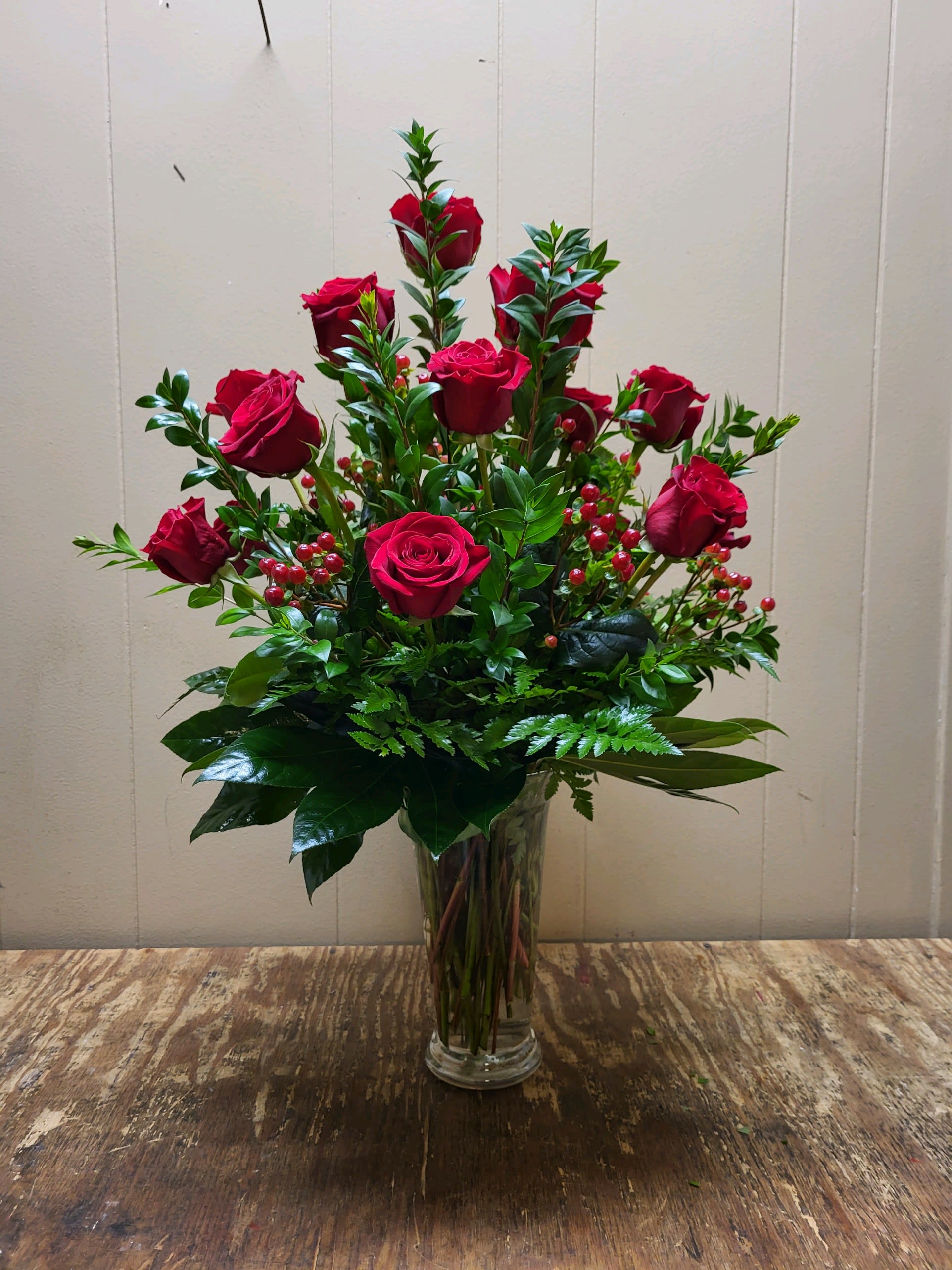 One Dozen Red Roses - Red roses have symbolized love and romance for centuries. One need only gaze at a classic red rose arrangement, like this one, to see why. Red roses are stunning, dramatic, and they say so much - without saying a word.  A dozen red roses with greens &amp; fillers are hand-delivered in a beautiful vase