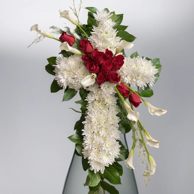 Eternal Remembrance Cross - Our Eternal Remembrance Cross standing easel arrangement is a heartfelt tribute of sympathy and memorial flowers designed in the shape of a white floral cross. This poignant creation features a blaze of red roses and delicate white calla lilies at the center, symbolizing love, purity, and remembrance. The Eternal Remembrance Cross stands as a beautiful and reverent expression of condolences and honors the memory of a loved one with grace and dignity. Pay tribute to a life well-lived with this symbolic arrangement that conveys comfort and solace during times of loss. Explore our compassionate floral offerings at Hignight Florist for more thoughtful creations that speak volumes of love and remembrance. What sets Hignight Florist apart is our commitment to exceptional customer service. We understand the sensitivity and urgency of funeral flower delivery, and strive to make the process as seamless as possible. Whether you need flowers delivered to a funeral home, church, or directly to a family member's home, Hignight Florist ensures prompt and reliable delivery.