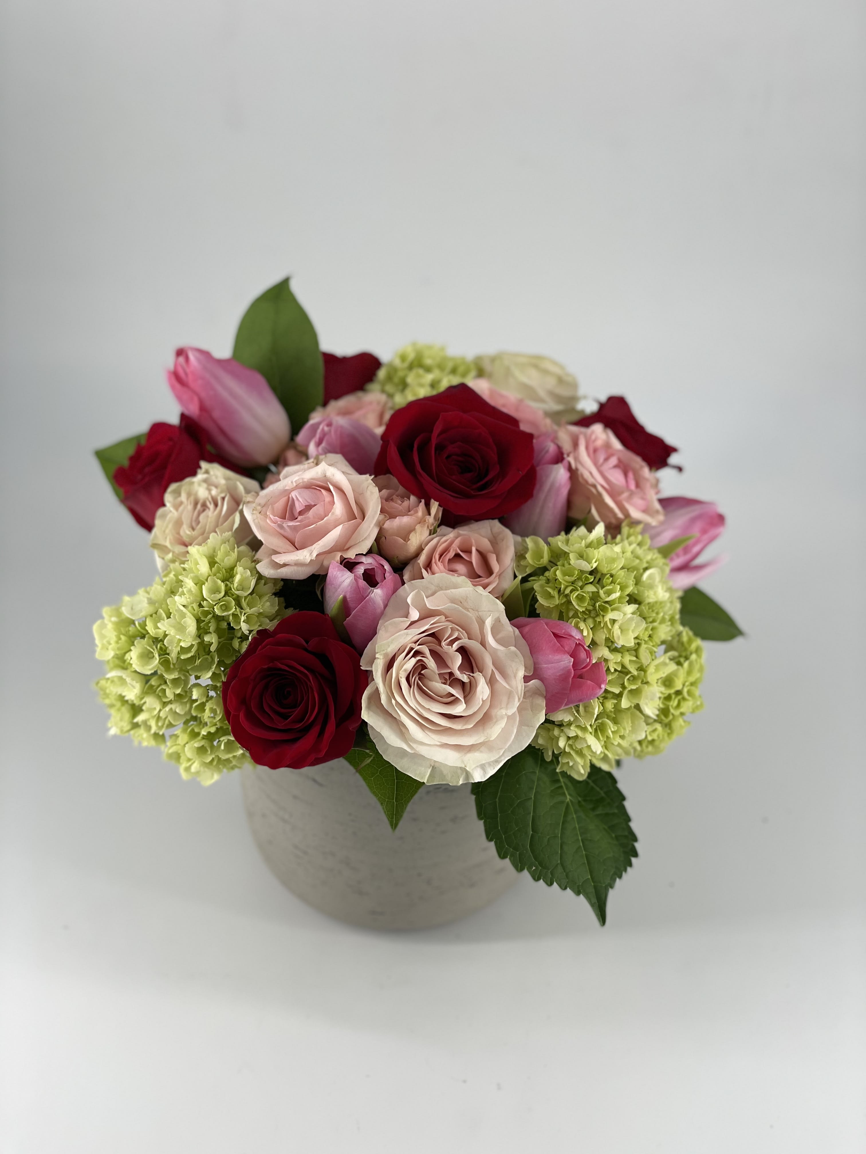 Amor - Amor is timeless gathering of romantic shaded blooms such as Roses, Tulips and Hydrangea. Sweetly clusterd blossoms express shades of affection to warm the heart.