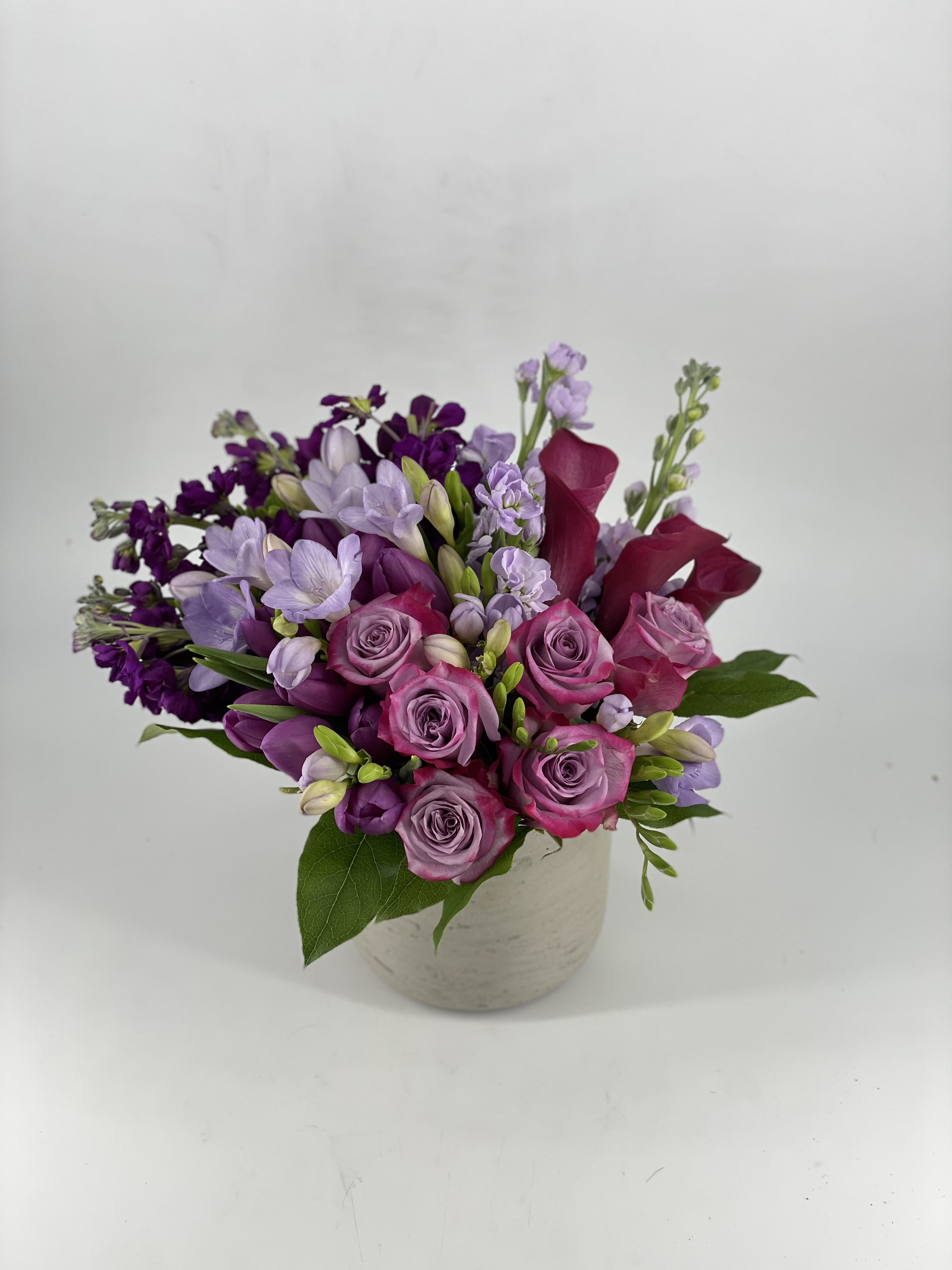 Purple Rain - Music is a an art that unites people all over the world. It’s beauty excels race, culture and background. We like to think the beauty of flowers achieves the same. This arrangement that showers shades of purple pays homage to Prince’s signature song and to his craft that bought joy to so many. We hope this arrangement continues that legacy. Shown in Deluxe Size.