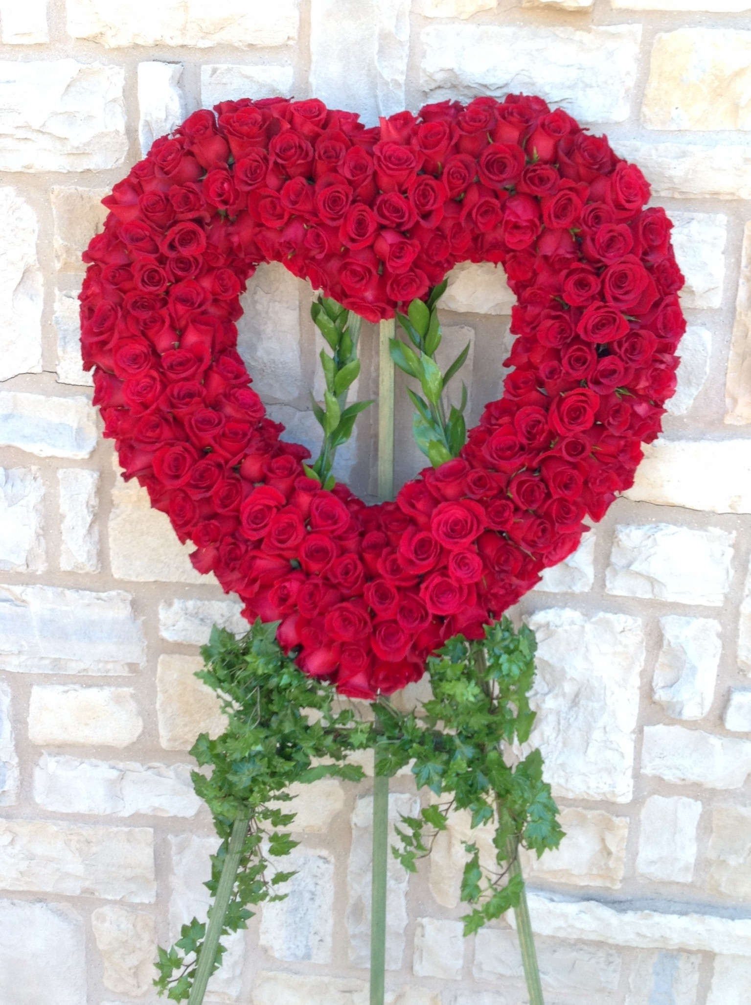 Roses are Red Open Heart Wreath - This funeral easel is a true statement piece for your loved one Memorial service. Made out of all Red roses, the room will be filled with loving memories.