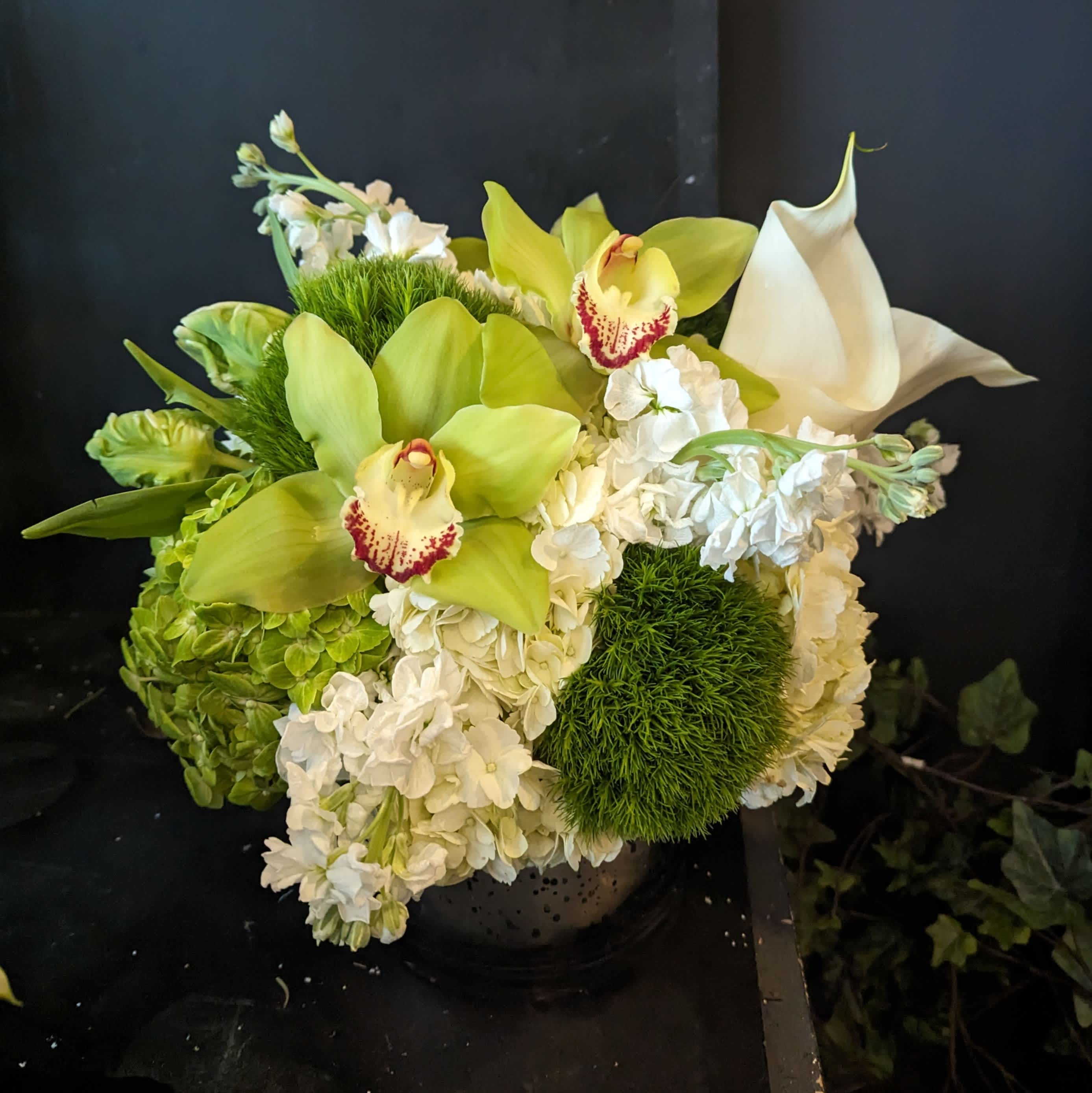 Petit Spring Citron de Blanc Petit Spring Citron de Blanc - A 6" silver mercury cylinder features parrot tulip, hydrangea, stock and orchids or calla lillies.