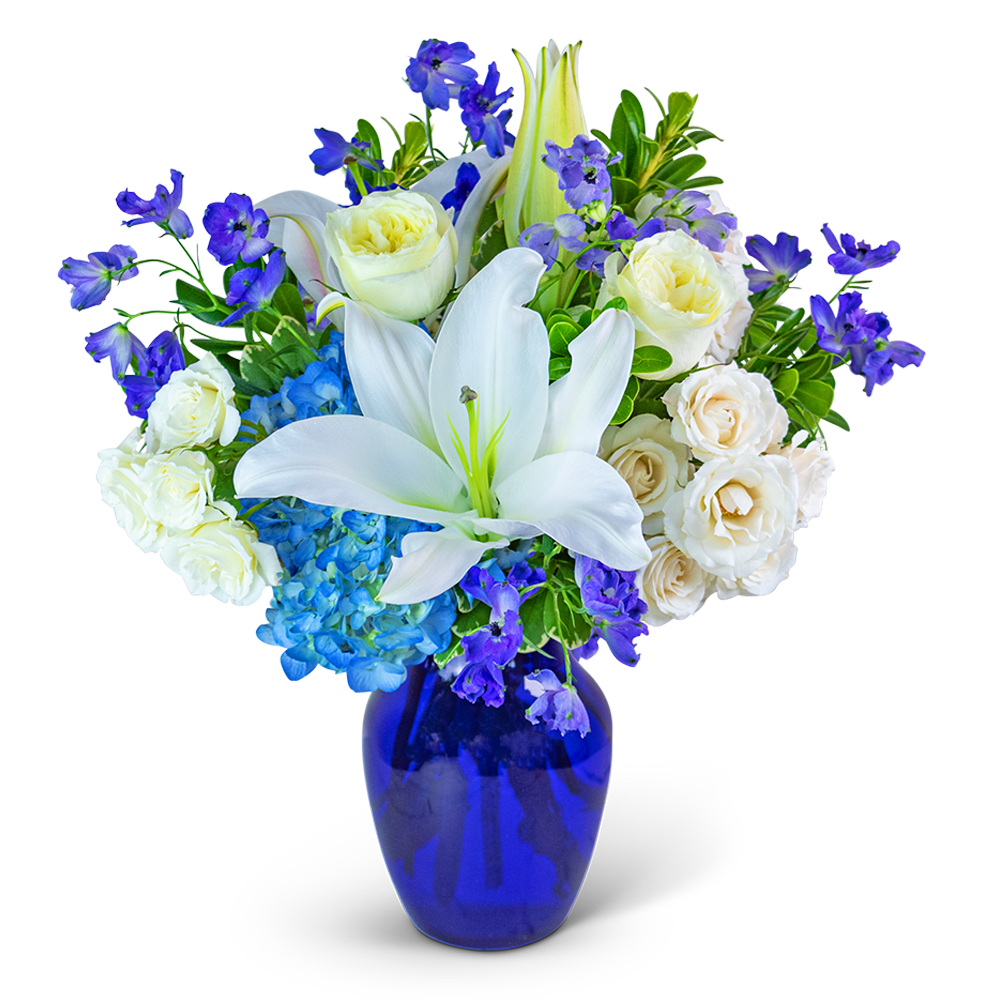 Blue Beauty - Our Blue Beauty flower design is meticulously created with hydrangea, lilies, Delphinium, roses, and an exquisite assortment of premium foliage. This stunning floral arrangement is beautifully presented in a striking blue glass vase, radiating a sense of tranquility and elegance. Transform any space into a haven of serenity with the enchanting Blue Beauty, a true testament to the captivating beauty of nature.