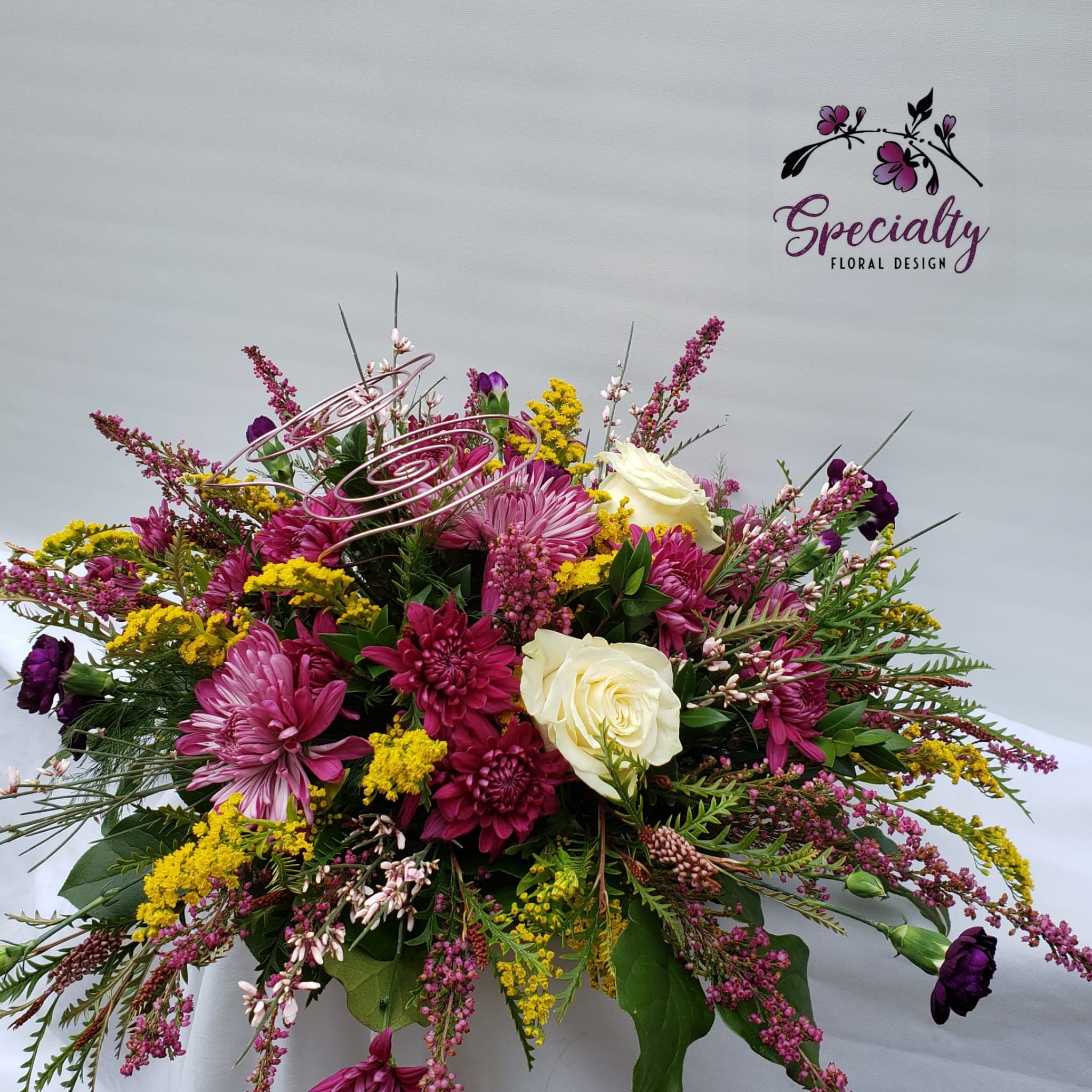 Funky wire Flower Bouquet - Welcome to our Olympia, WA Flower Shop - Where Creativity Blossoms!  Are you in search of a floral arrangement that goes beyond the ordinary? Look no further! At our flower shop in Olympia, WA, we take pride in crafting unique and funky floral creations that are perfect for those with a taste for the extraordinary.  Our standout arrangement features a vibrant combination of flowers, including stunning purple disbuds, charming purple mini carnations, sunny yellow solidago, elegant white roses, and delicate pink heather. But what makes this bouquet truly special is the artistic touch of wire weaving its way through the blooms. Each wire design is a unique masterpiece, carefully tailored to suit the occasion and add that extra flair.  These handcrafted bouquets are not only visually captivating but also easy to care for. Simply provide them with a daily dose of water, and you'll have a captivating display of nature's beauty in your home or office. What sets this arrangement apart is its versatility – it looks stunning from every angle, making it suitable for any space.  One of the key advantages of our floral creations is their longevity. These flowers are exceptionally long-lasting, ensuring that your recipient can enjoy their beauty for days on end.  So, if you're searching for flowers in Olympia, WA that are as unique as the person you're gifting them to, look no further. Our one-of-a-kind arrangements are here to bring joy and a touch of funkiness to any occasion. Order yours today and experience the magic of our creative floral designs.