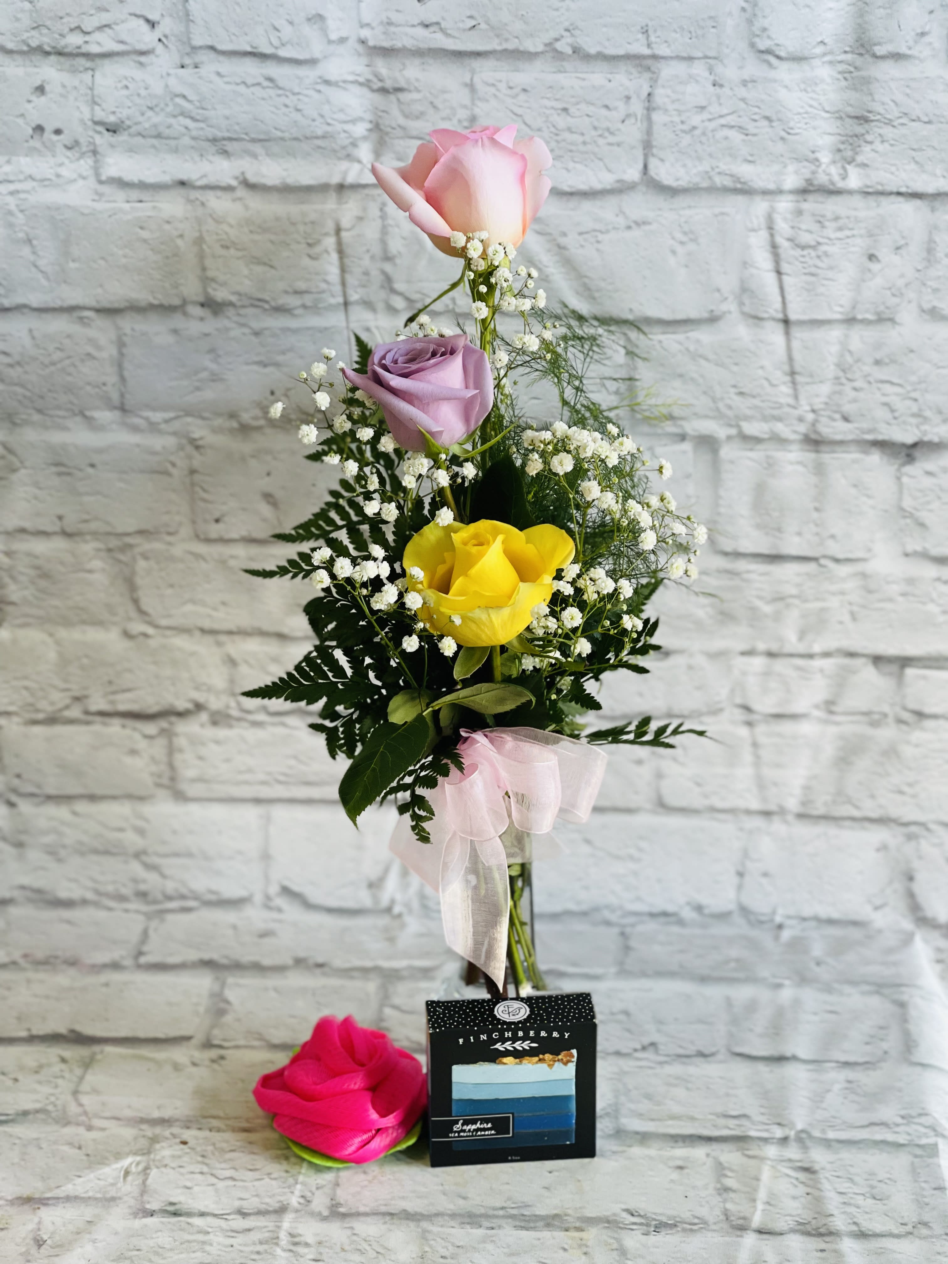 Buds and Suds - Our popular Buds arrangement (three colored roses in a bud vase) Accompanied by a beautiful bar of Finchberry, handcrafted, Vegan soap &amp; a rose shaped bath loofah!! Color of roses and soap may vary, but as always call us if you have a preference.