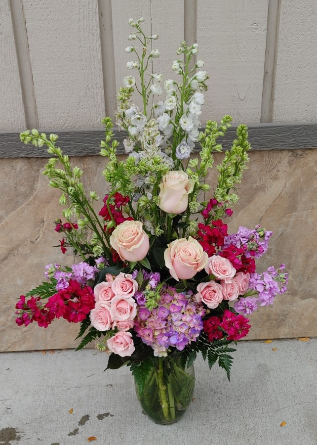 Elegant Dreams - Elegant beauty stems from within this lovely arrangement of larkspur, snapdragons and spray roses that are gathered gracefully in a glass vase. 