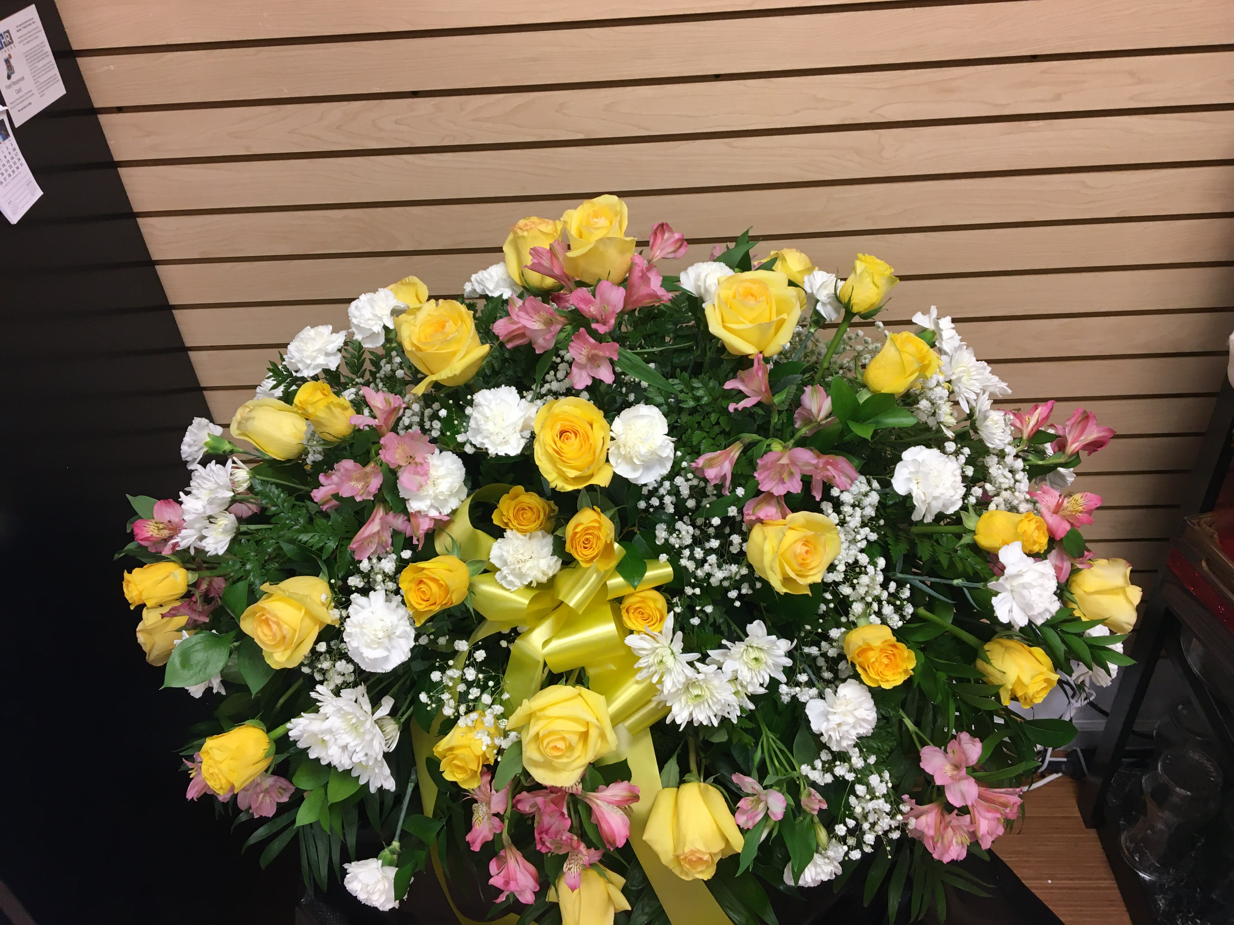 Saddle Casket Spray with Yellow Roses - Casket spray with white carnations, yellow roses, pink alstroemeria, and baby breathe