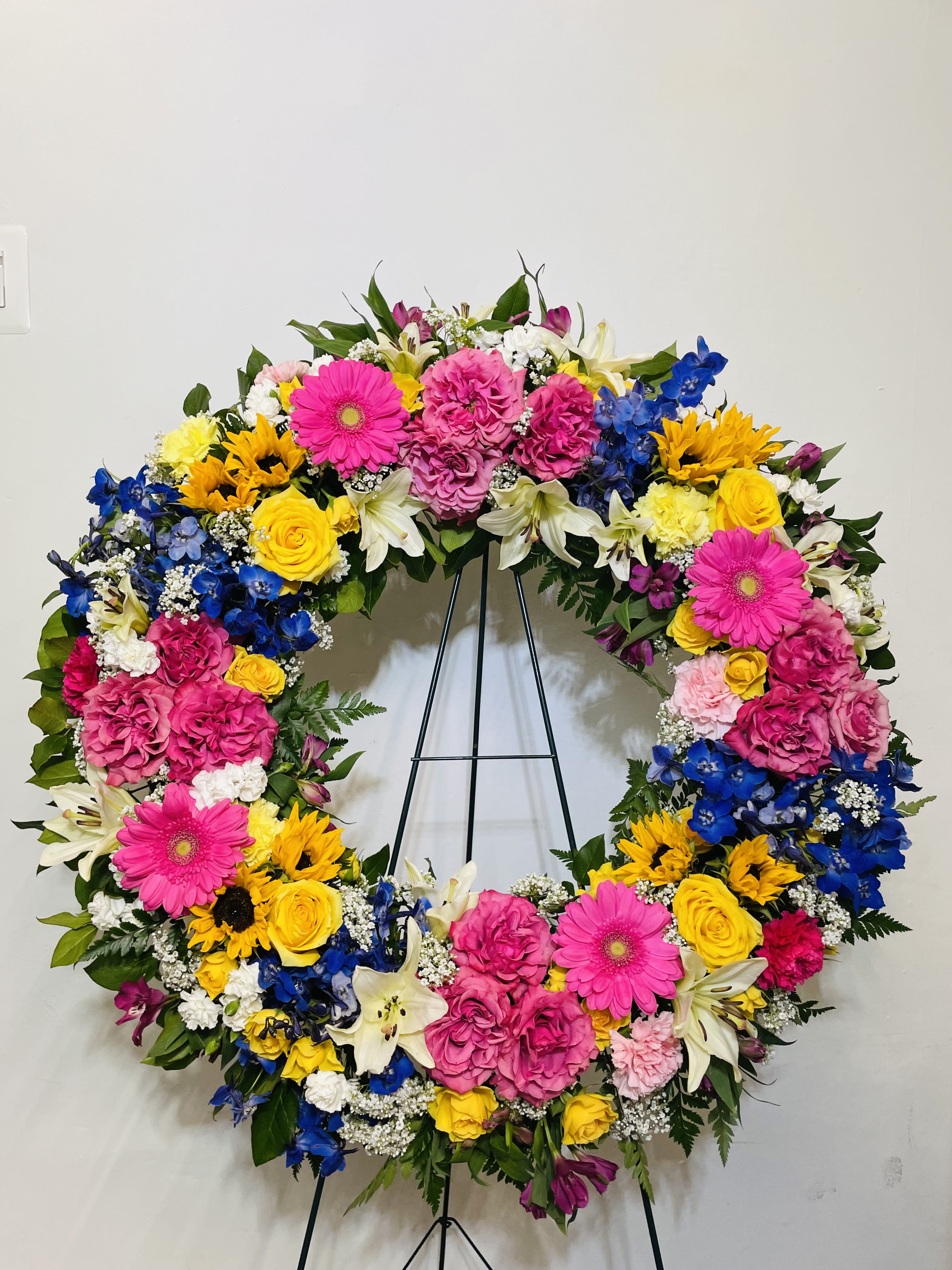Ringed by Love Wreath Ringed by Love Wreath - This colorful and bright wreath spray is representative of a life lived to its fullest. Colors and Flowers may change based off of season and availability.