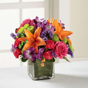 The FTD® Birthday Cheer™ Bouquet - Birthday blooms that are ready to get your recipient's special day started, this flower bouquet is bright, happy, and ready to celebrate! Hot pink roses and orange Asiatic Lilies are vibrant and fun surrounded by purple Peruvian Lilies, hot pink mini carnations, green button poms, purple statice, and an assortment of lush greens. Accented with assorted curling ribbons to give it that party feel and presented in a clear glass cubed vase lined with ti leaf green material for added beauty, this unforgettable birthday bouquet is that ultimate surprise that will make them feel the love on their big day. GOOD bouquet includes 11 stems. Approx. 10&quot;H x 10&quot;W. BETTER bouquet includes 15 stems. Approx. 11&quot;H x 11&quot;W. BEST bouquet includes 19 stems. Approx. 12&quot;H x 12&quot;W. 