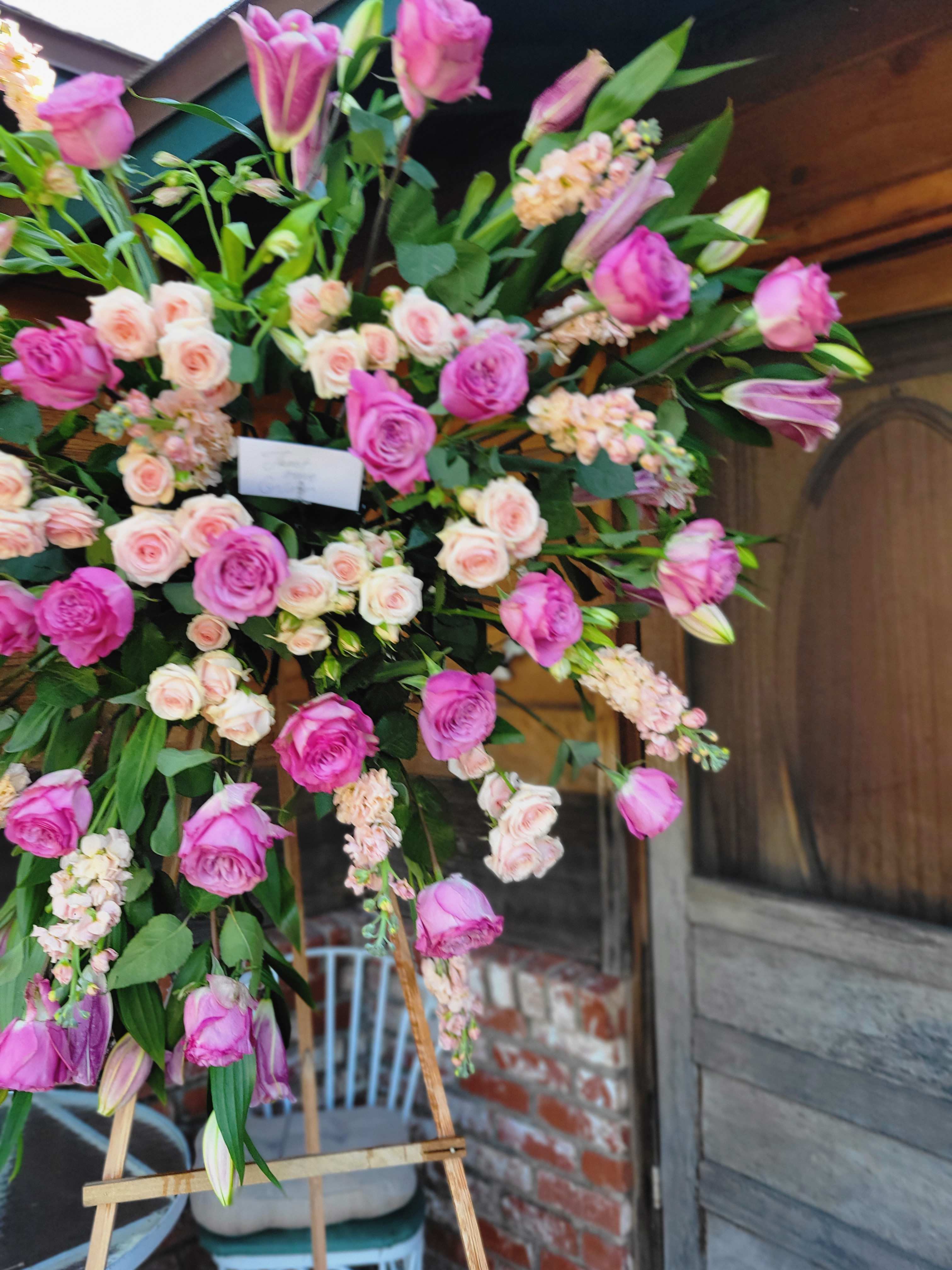Forever Treasured Double Standing Funeral Spray - This pink and white standing funeral spray is designed with a double cage and comes readily equipped with a stand. It features 2 dozen pink roses, lilies, snap dragons, spray roses, and stock.