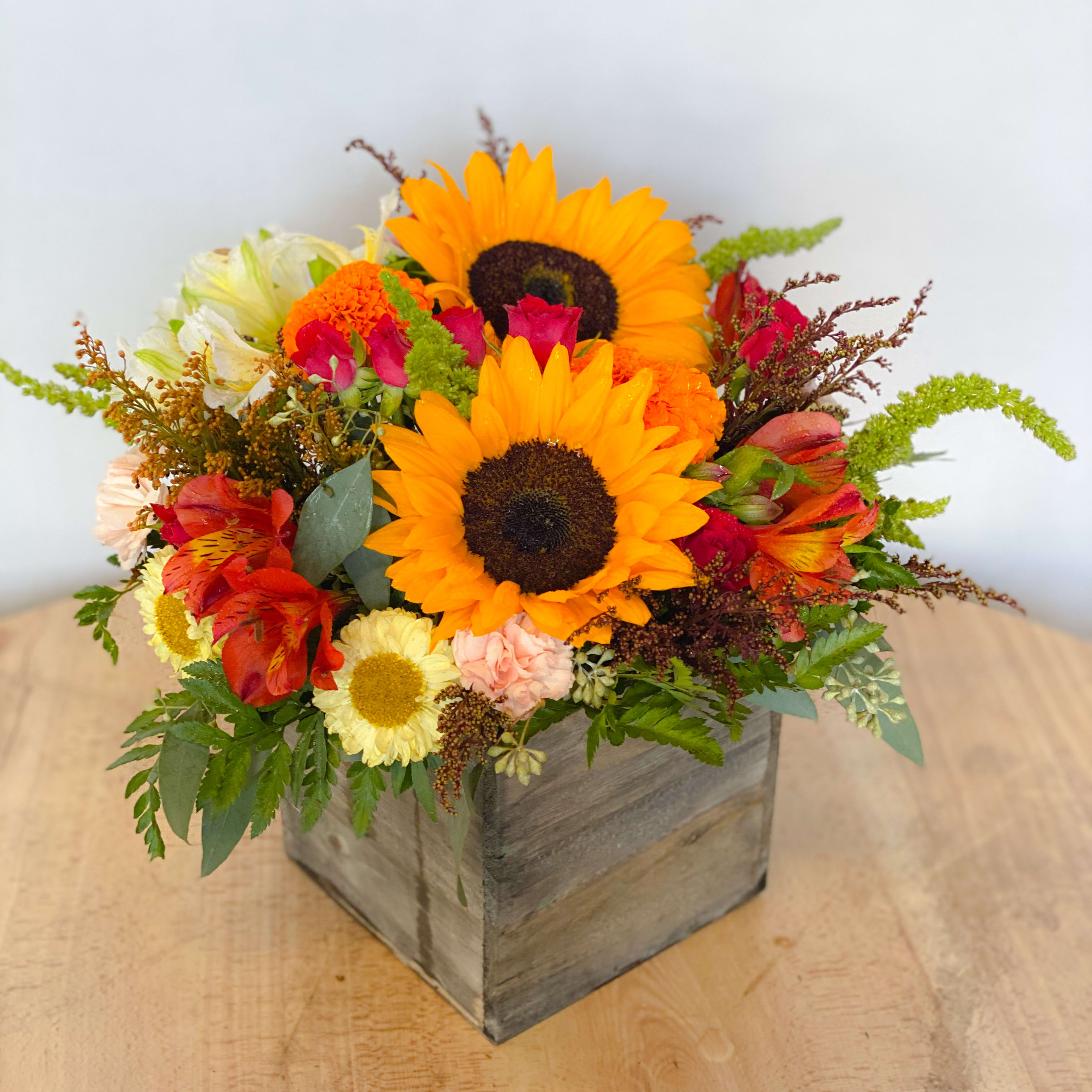 A Box Of Cheer  - A box full of cheerfulness to send to your family and friends! This bouquet of sunflowers, roses, matsumoto asters and alstroemerias arranged bright and beautiful in this keepsake textured wood container will definitely be a great gift for all occasions.   Approximately 9” D