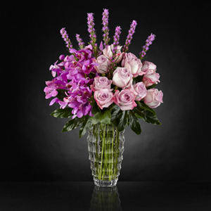 The FTD® Modern Royalty™ Luxury Bouquet The FTD® Modern Royalty™ Luxury Bouquet - Opulent in every way to bring a certain majesty to any place it may be set, this stunning flower bouquet exudes true artistry through its use of color and texture. Notice the lavender swirl of roses offset by the fanciful layers of petals brought on by stems of lavender Mokara Orchids with a crown of purple liatris extending from the top. Arranged to perfection in a clear faceted glass vase to add even further texture and interest as it reflects light from its surroundings, this gorgeous luxury bouquet is ready to turn an ordinary day into something quite extraordinary indeed. IMPRESSIVE bouquet includes 26 stems. Approx. 26"H x 17"W. STUNNING bouquet includes 37 stems. Approx. 27"H x 18"W.