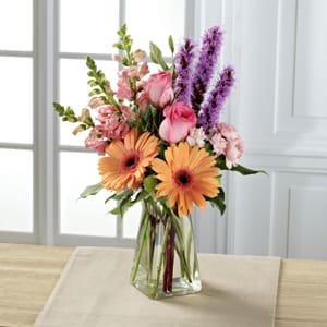 The FTD® Blushing Invitations™ Bouquet The FTD® Blushing Invitations™ Bouquet - Exuding a special charm, with a casual fresh-from-the-garden look, this gorgeous spring bouquet is the perfect way to delight your recipient in honor of any of life's most treasured moments. Peach gerbera daisies are soft and sophisticated surrounded by pink roses, pink snapdragons, pink mini carnations, purple liatris, and lush greens arranged with an artist's eye in a gathered square clear glass vase. A wonderful way to celebrate a spring birthday, Mother's Day, or to express your thanks and gratitude. GOOD bouquet includes 12 stems. Approx. 16"H x 7"W. BETTER bouquet includes 15 stems. Approx. 18"H x 8"W. BEST bouquet includes 18 stems. Approx. 23"H x 10"W.
