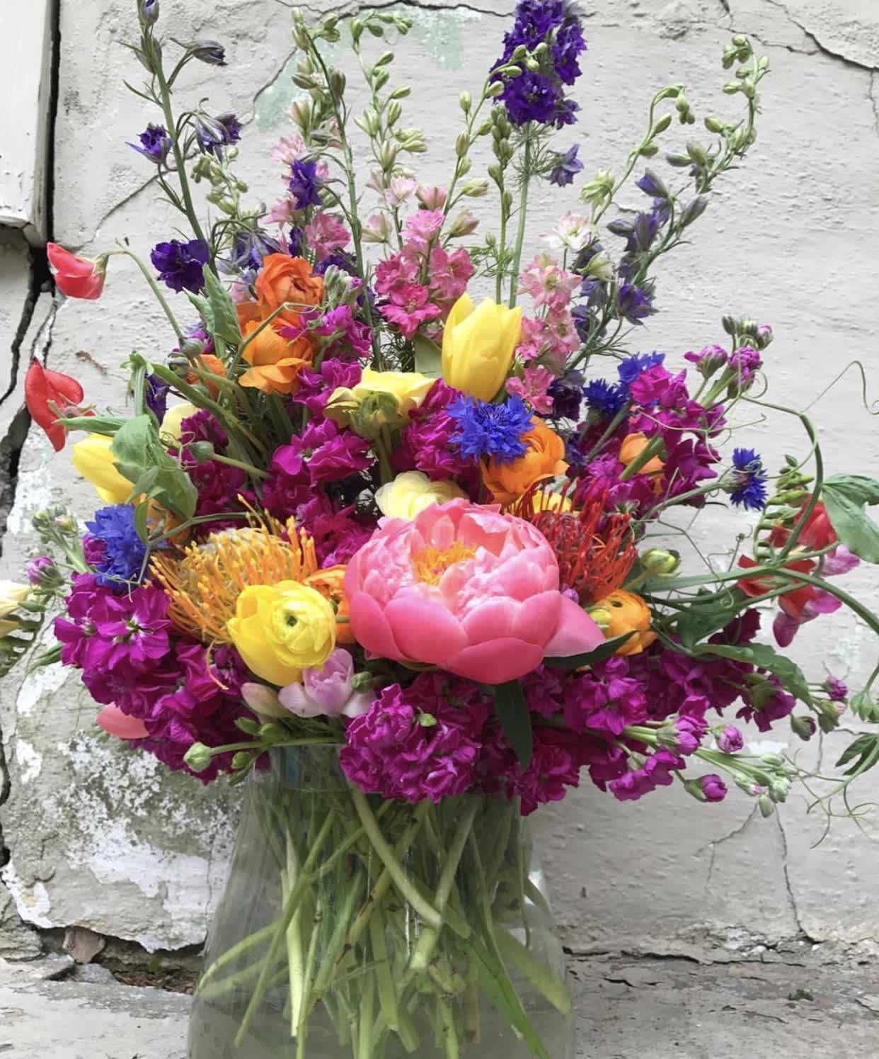 Colorado Spring Colorado Spring - This beauty is bursting with color and wild blooms, just like you would find growing in the Mountains and Meadows of Colorado! This arrangement is sure to brighten anyone's day and fill any room with joy!