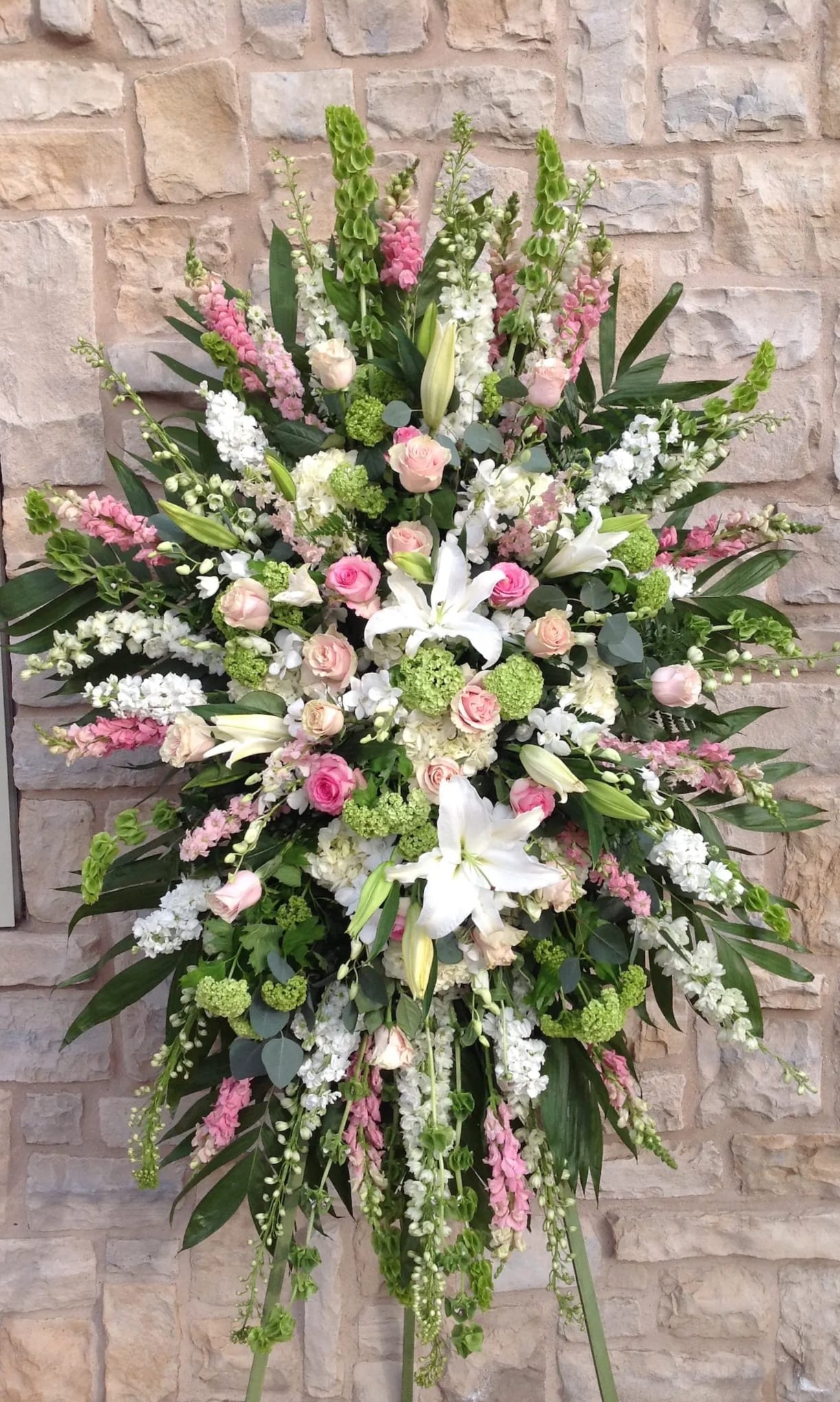 Pink Funeral Standing Spray Easel - This beautiful standing spray includes Roses, Hydrangeas, Lily's, Snap dragons, Bells of Ireland, Larkspur, and stock 