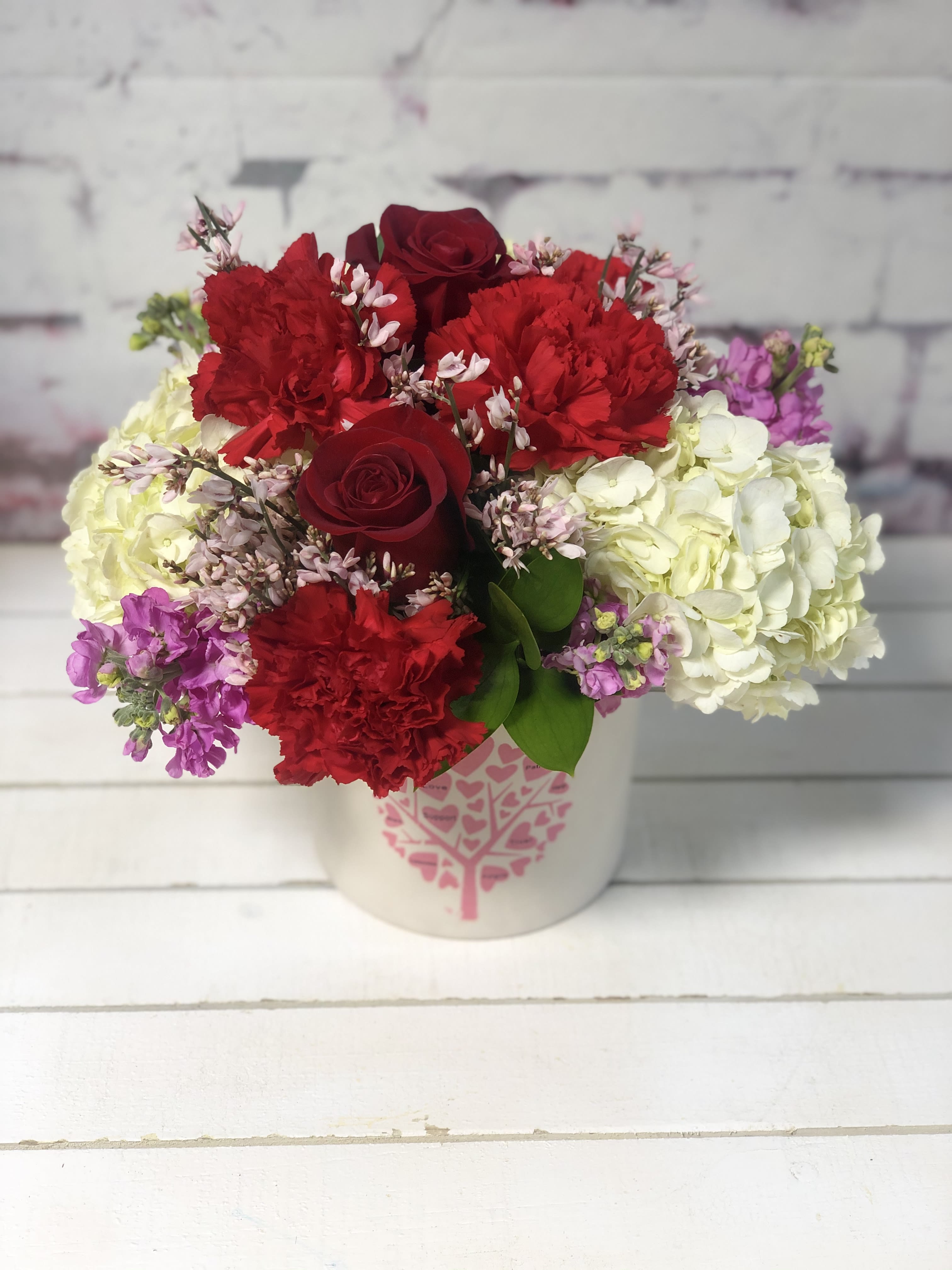 True Love - Keepsake container filled with  carnations, hydrangea, stock and roses. 